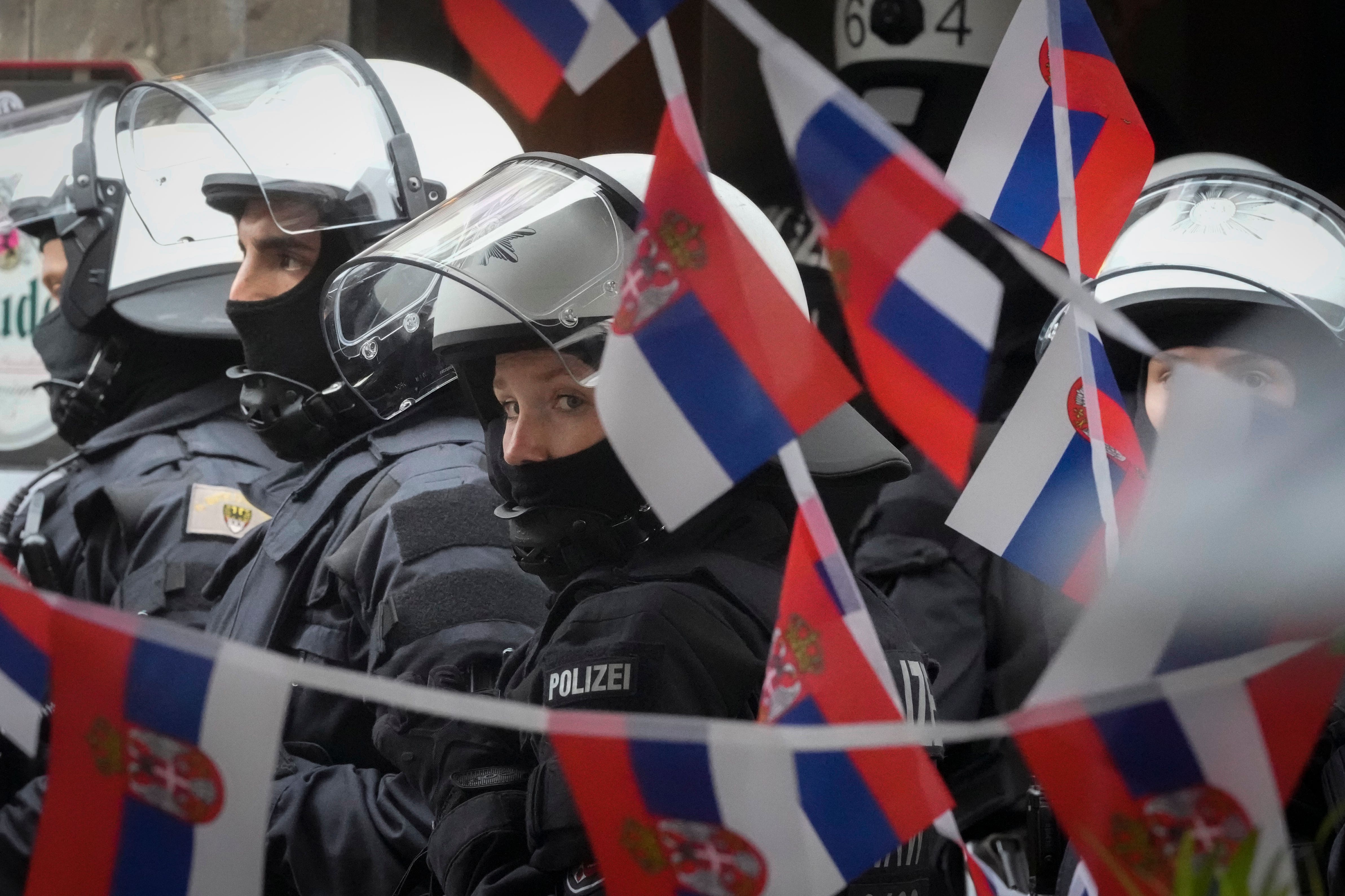 Police stand next to a restaurant decorated with Serbian flags ahead of the Euro 2024 Group C match against England (Markus Schreiber/AP)