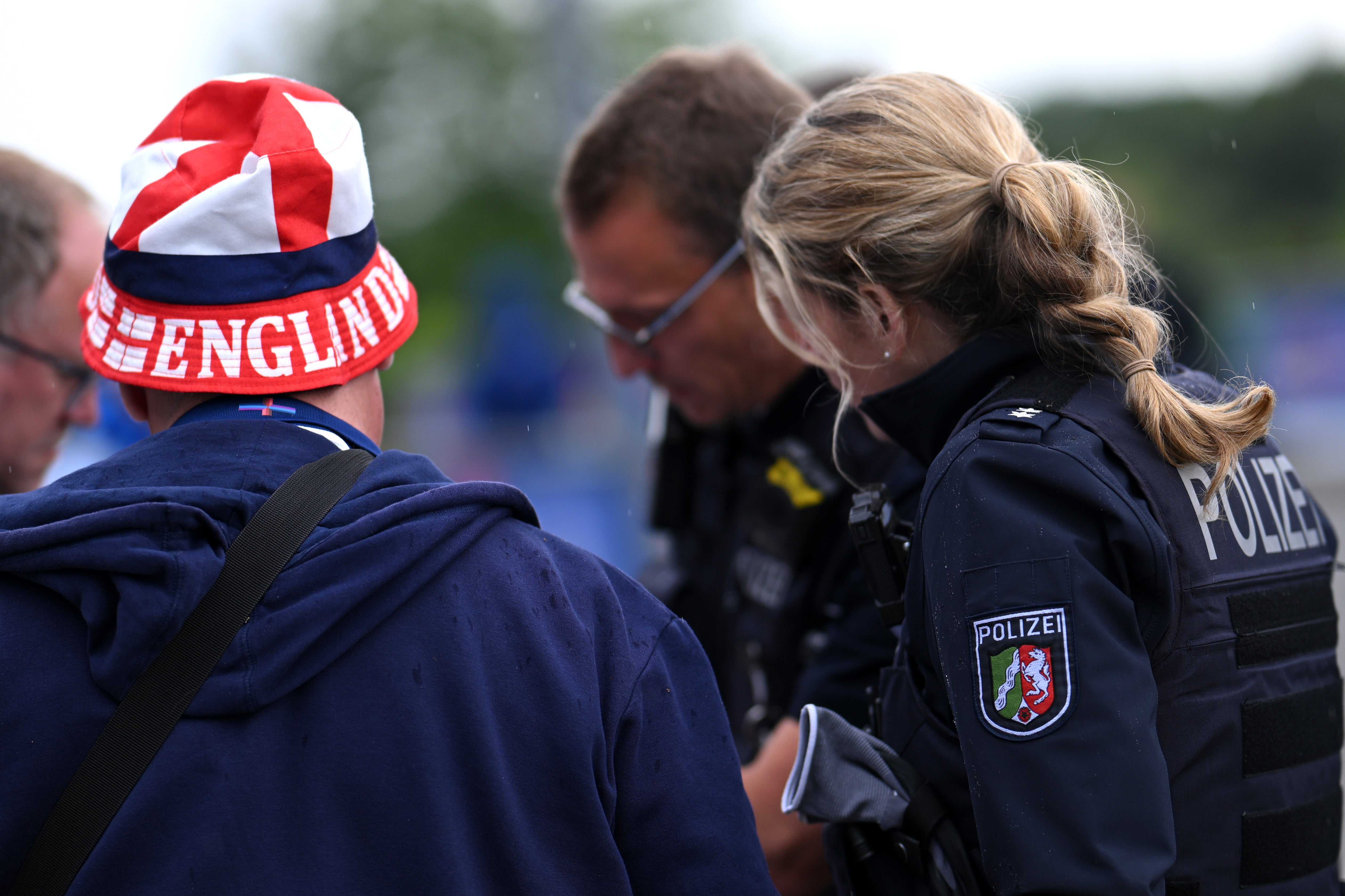 An England football fan speaks with a German police officer before the game against Serbia