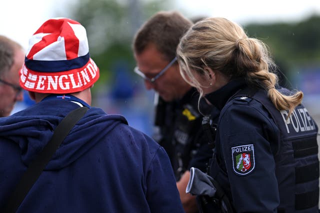 <p>An England football fan speaks with a German police officer before the game against Serbia</p>