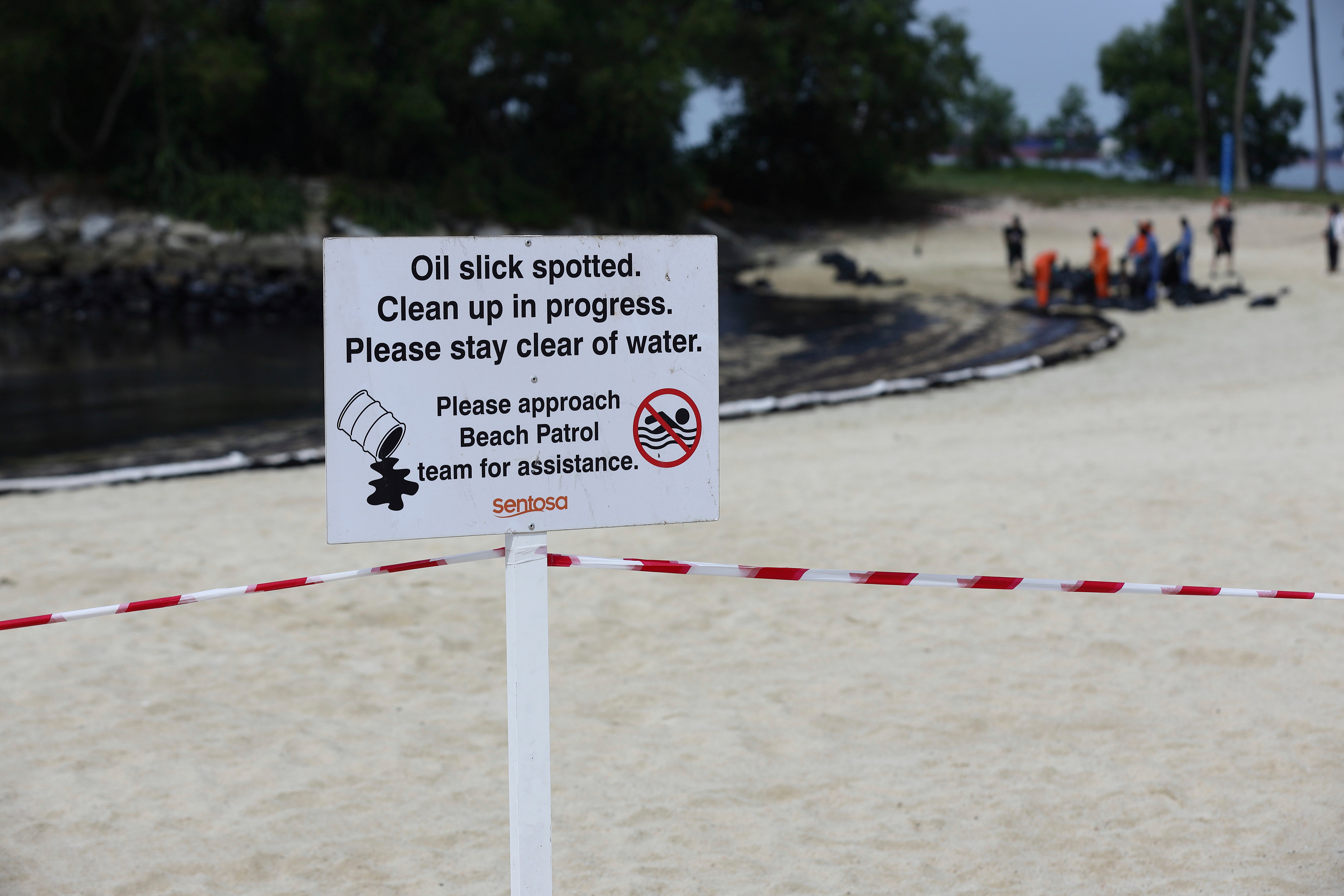 A signboard warning of oil spill is seen along Sentosa's Tanjong Beach area in Singapore