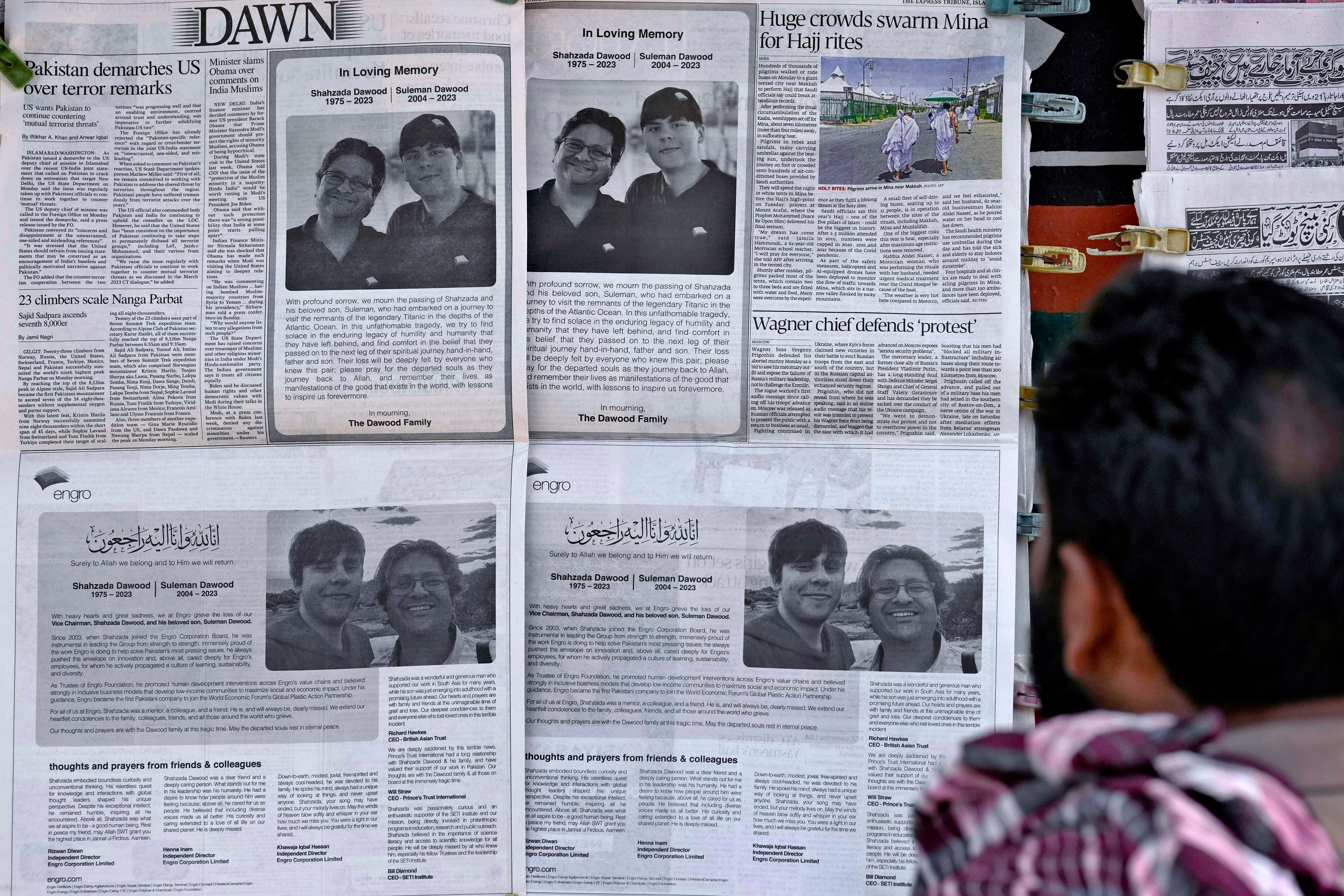 A man looks at morning newspapers which published condolence messages for two victims of Titan submersible incident