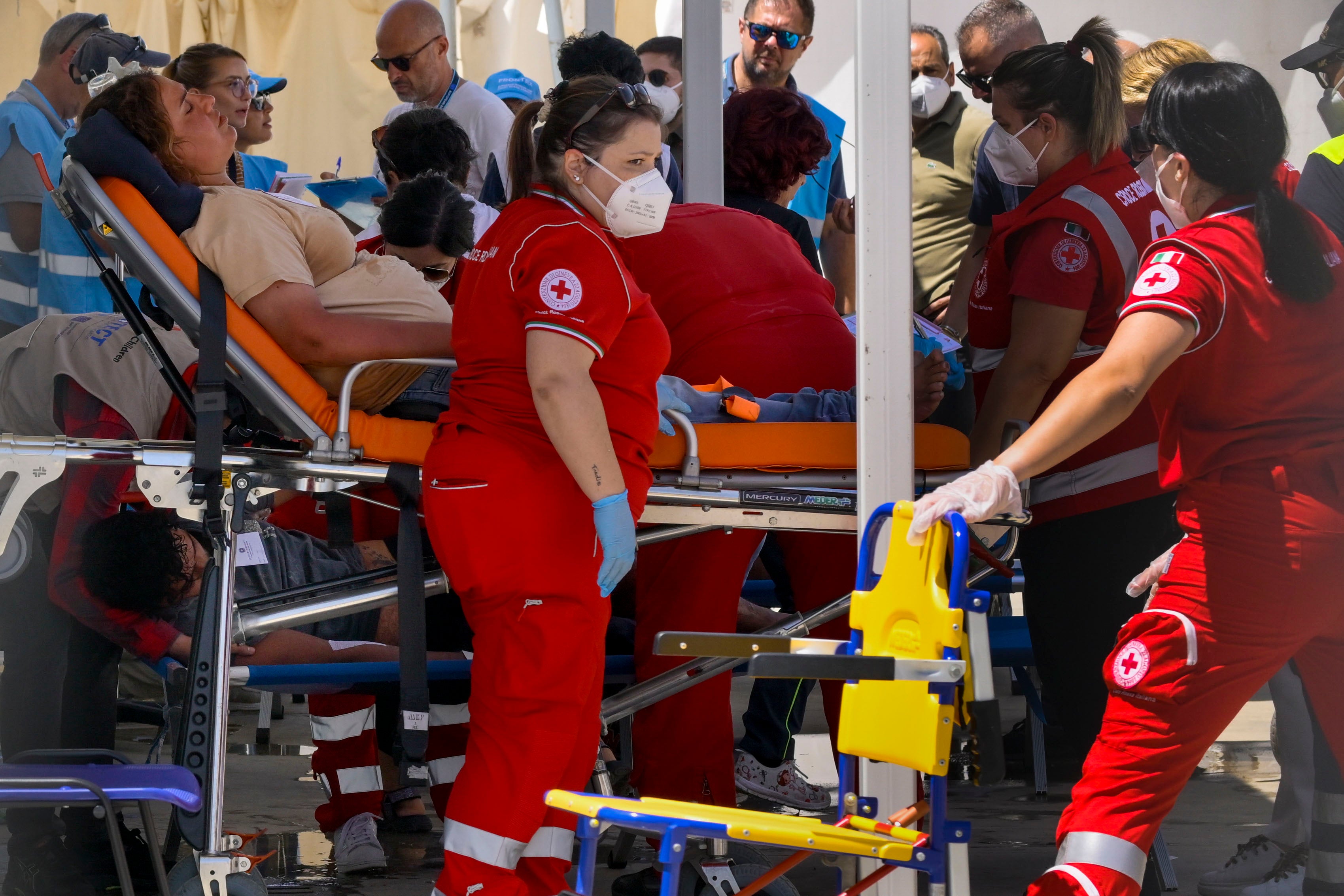 Some of the 11 migrants saved from the sea after their sailboat sank in the Mediterranean Sea between Italy and Greece early Monday, June 17, 2024, are assisted in Roccella Ionica, southern Italy where they were brought by the Italian Coast Guard