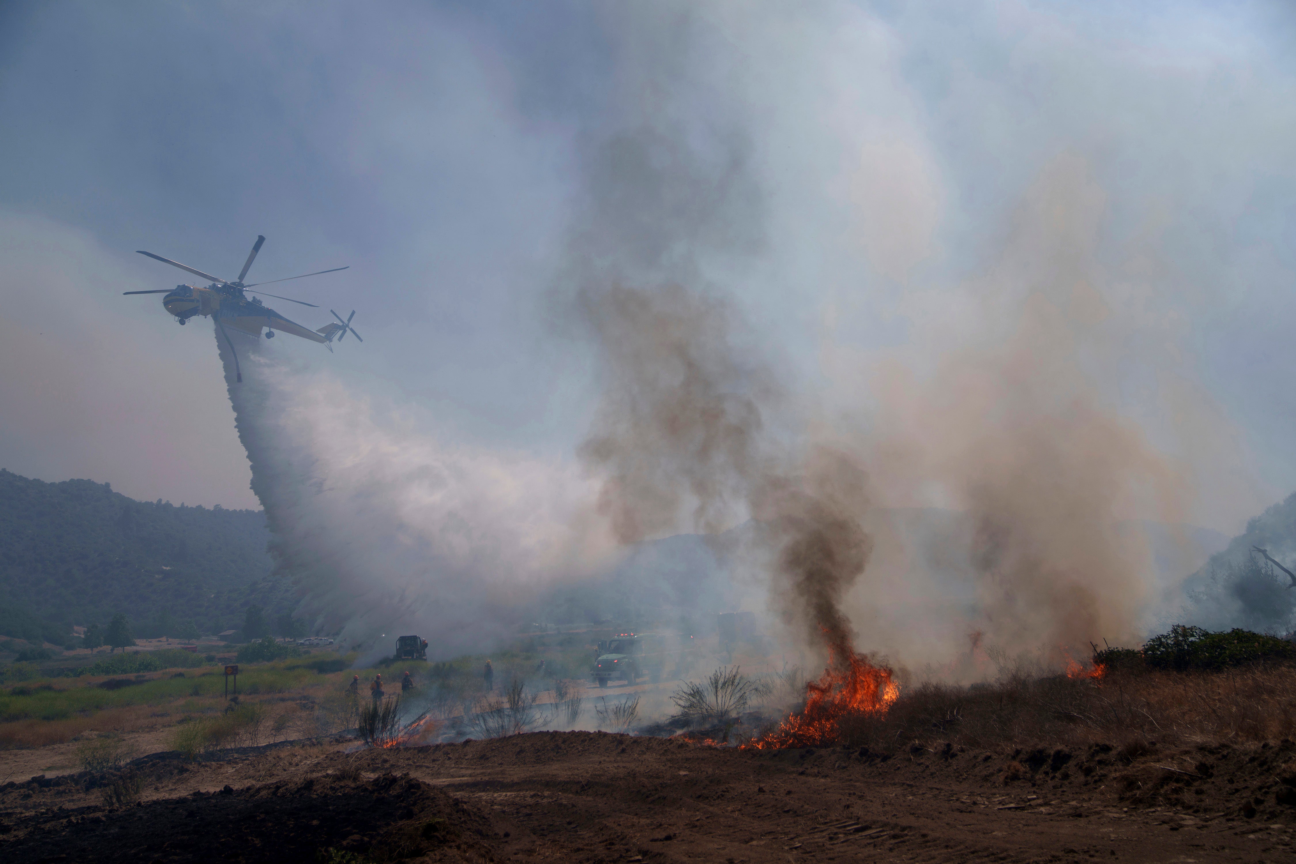 Water is dropped by helicopter as crews fight the Post Fire, Sunday, June 16, 2024, in Lebec, California