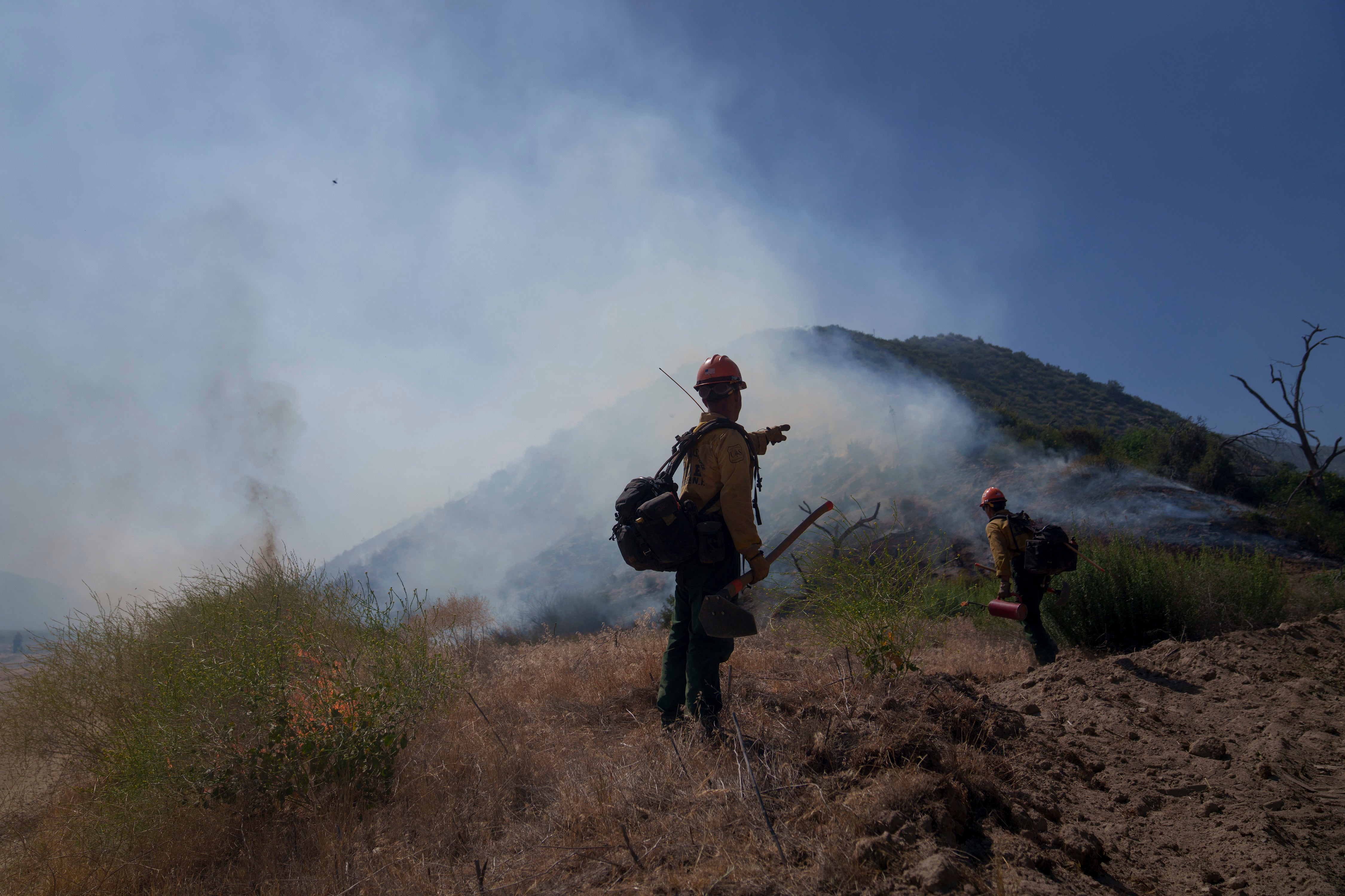 Firefighters work against the advancing Post Fire on Sunday, June 16, 2024, in Lebec, California