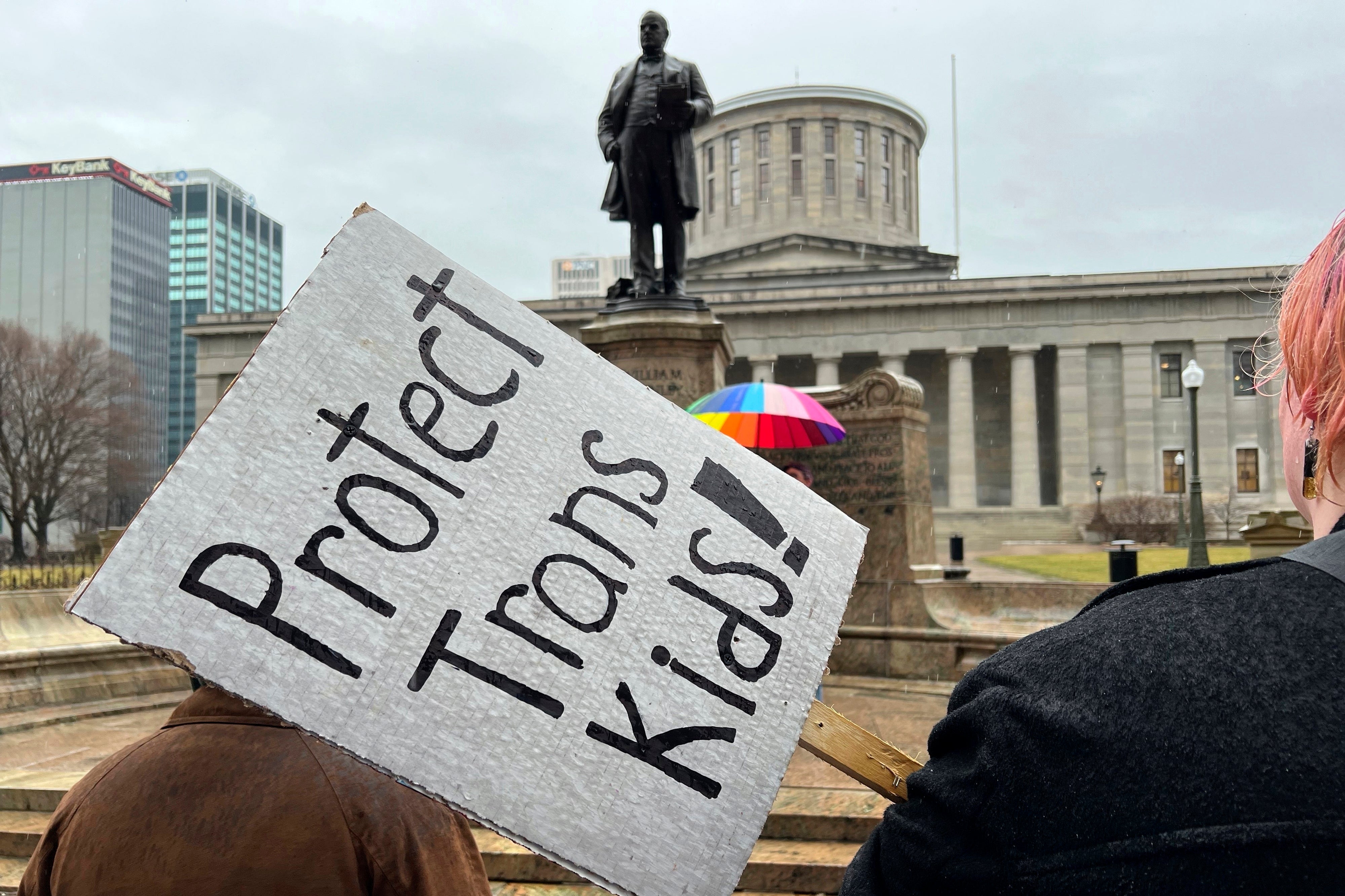 Demonstrators advocating for transgender rights and healthcare stand outside of the Ohio statehouse in January 2024.