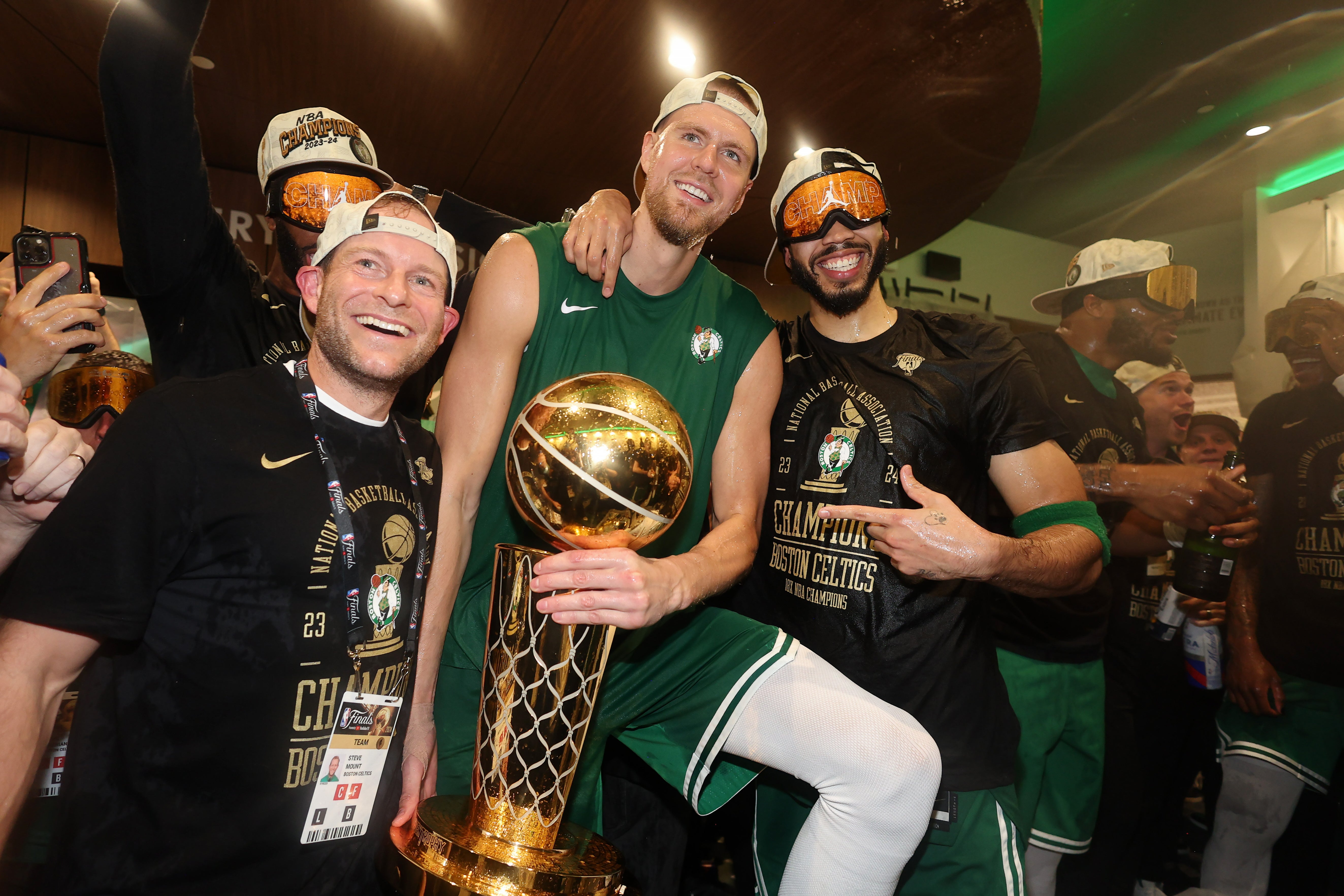 Kristaps Porzingis and Jayson Tatum celebrate with the trophy