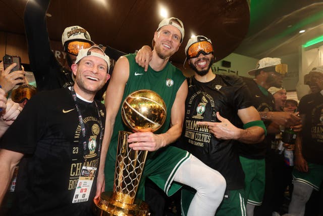 <p>Kristaps Porzingis and Jayson Tatum celebrate with the trophy </p>