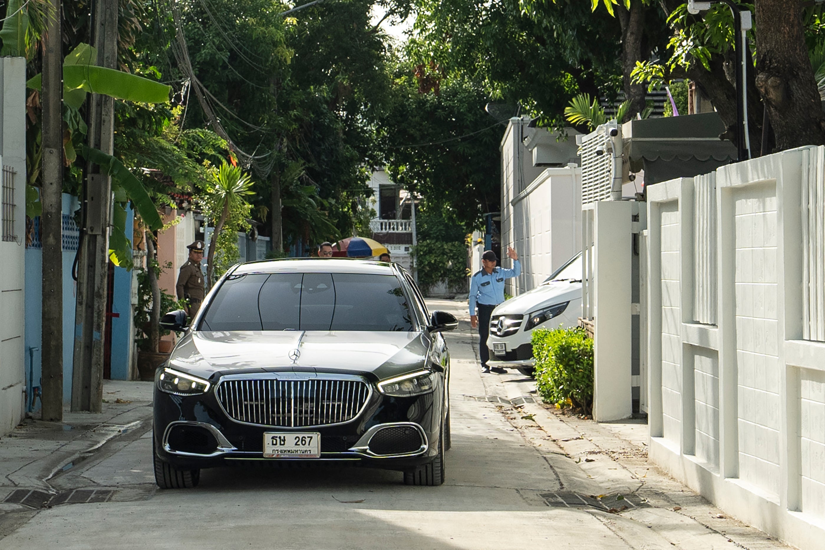 Cars in the convoy of Thailand's former prime minister Thaksin Shinawatra leave his residence in Bangkok