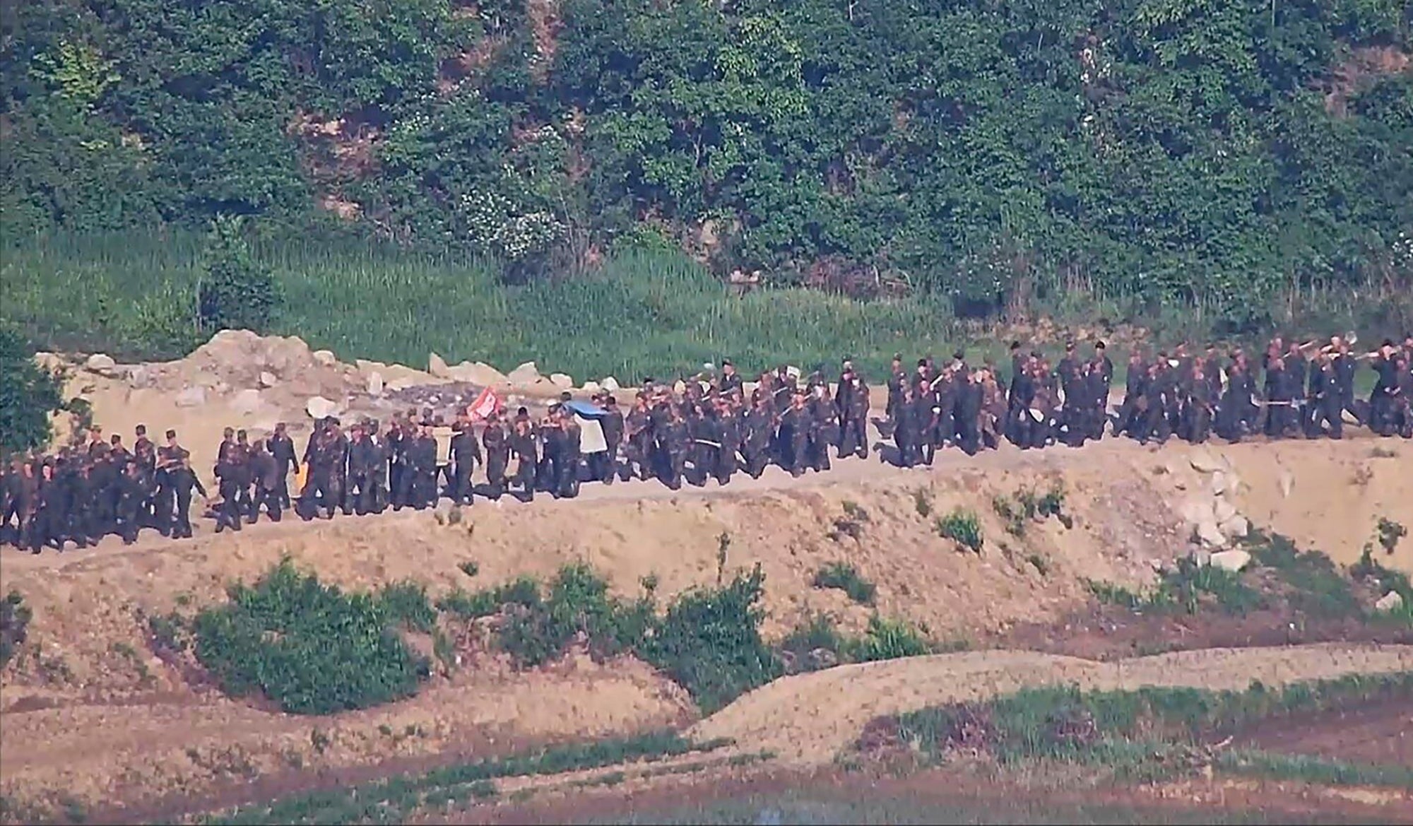 In this undated photo provided on Tuesday, June 18, 2024, by South Korea Defense Ministry, North Korean soldiers work at an undisclosed location near the border area, as seen from a South Korean guard area