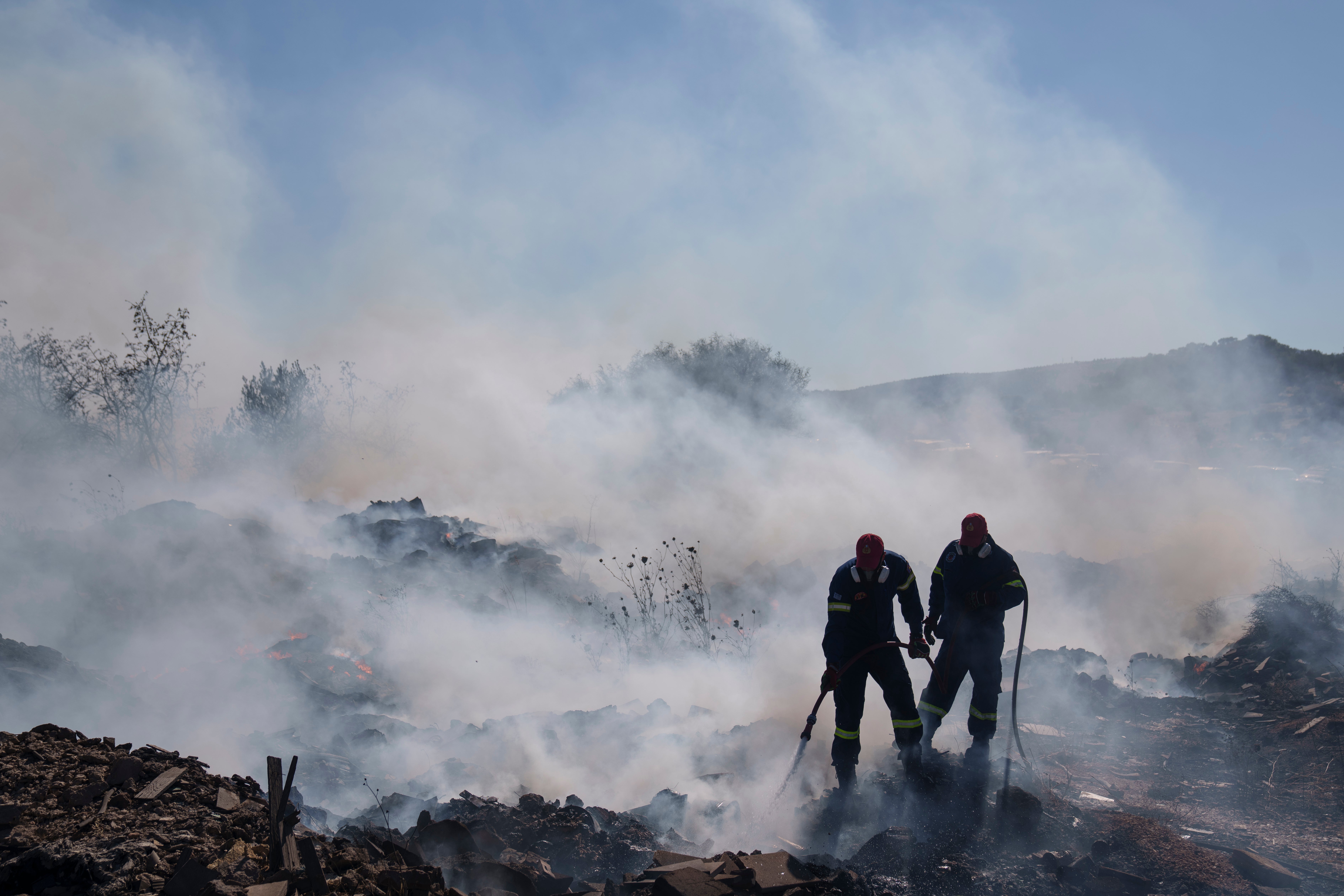 Firefighters try to extinguish the fire burning in Koropi suburb, eastern part of Athens, Wednesday, June 19, 2024