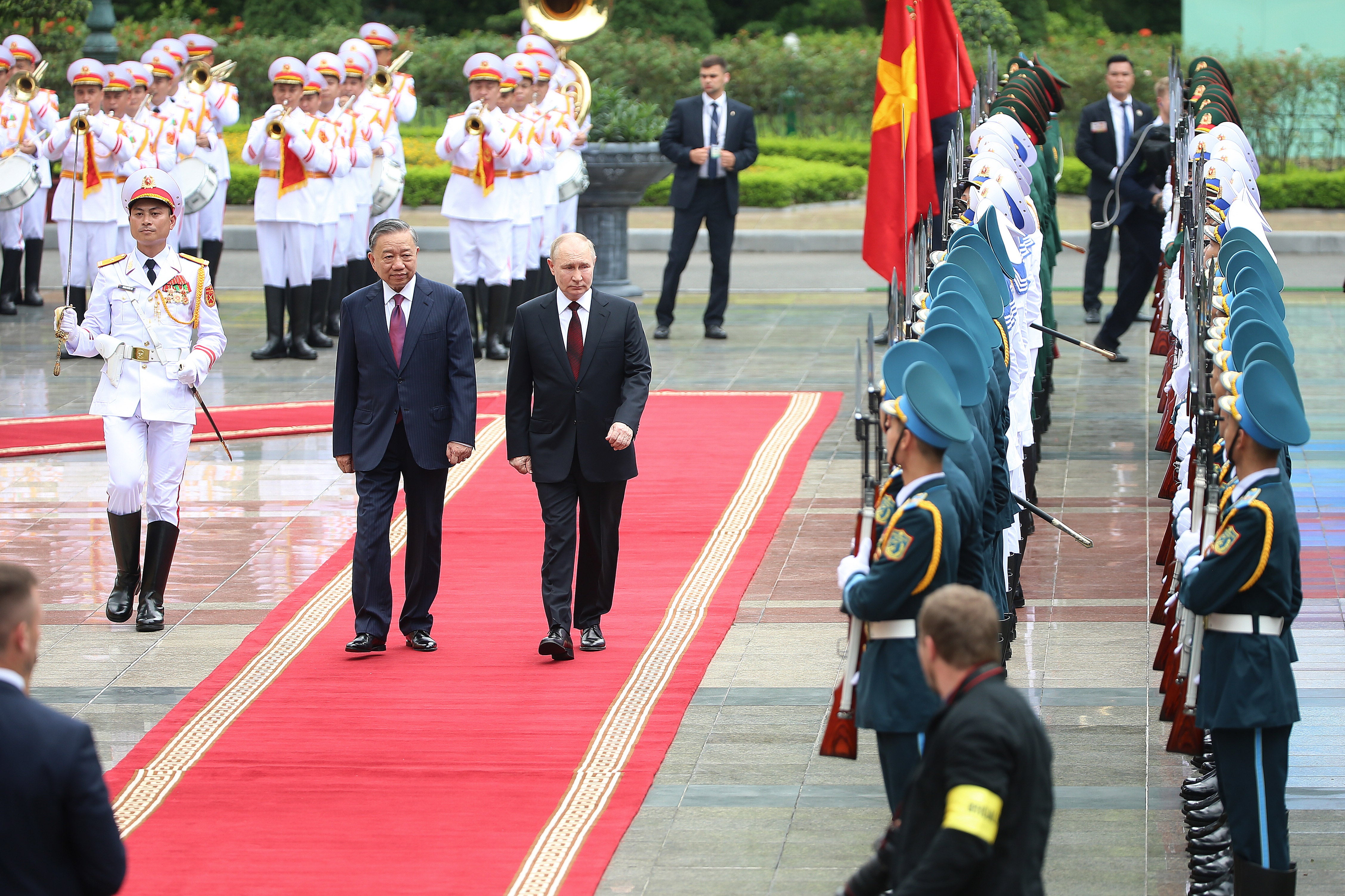 Vietnamese President To Lam (C-L) and his Russian counterpart Vladimir Putin (C-R) review the guard of honor at the Presidential Palace in Hanoi, Vietnam