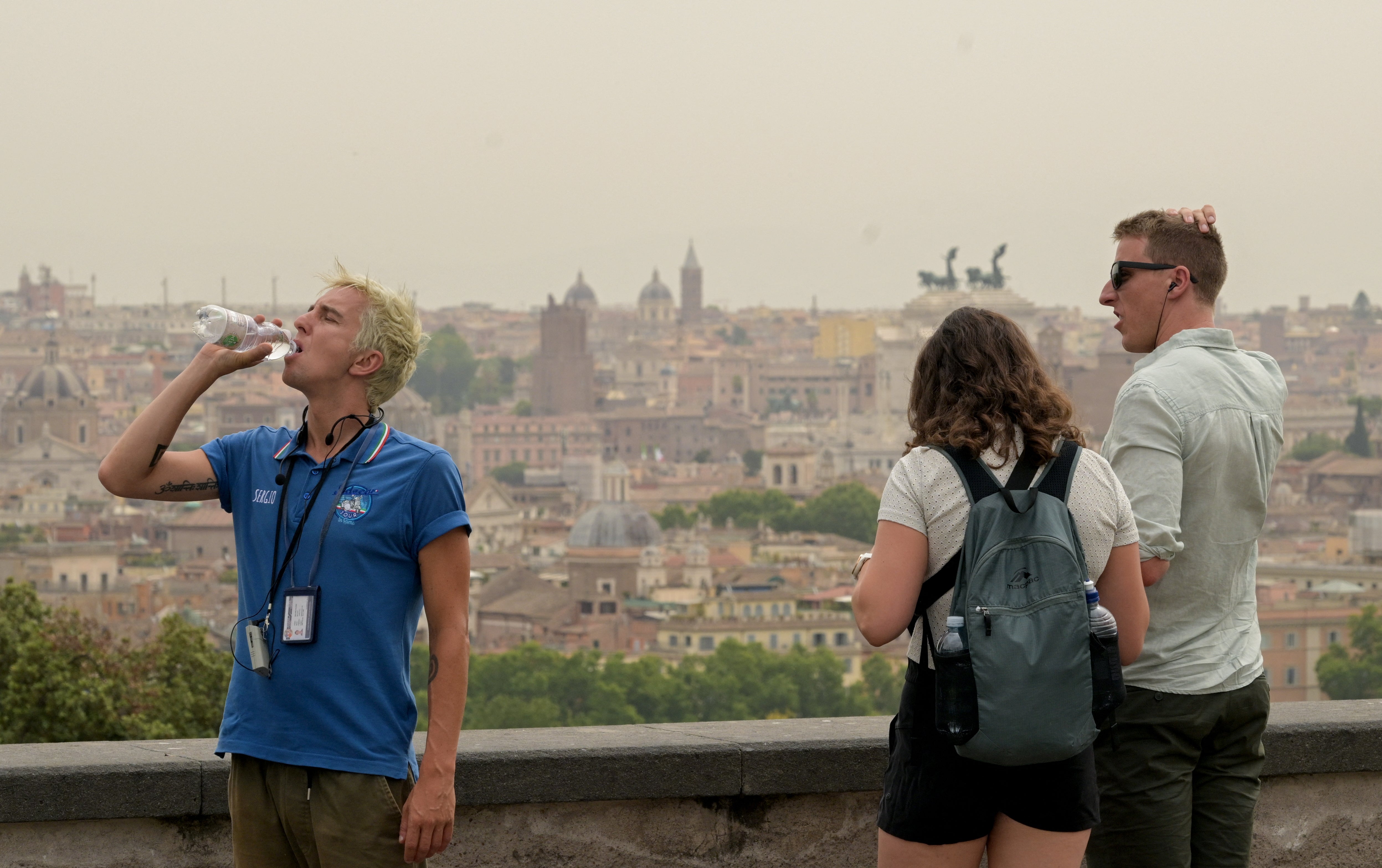 A man drinks water as a haze of heat is seen above Rome with temperatures expected to rise to 39 degrees today on June 20, 2024