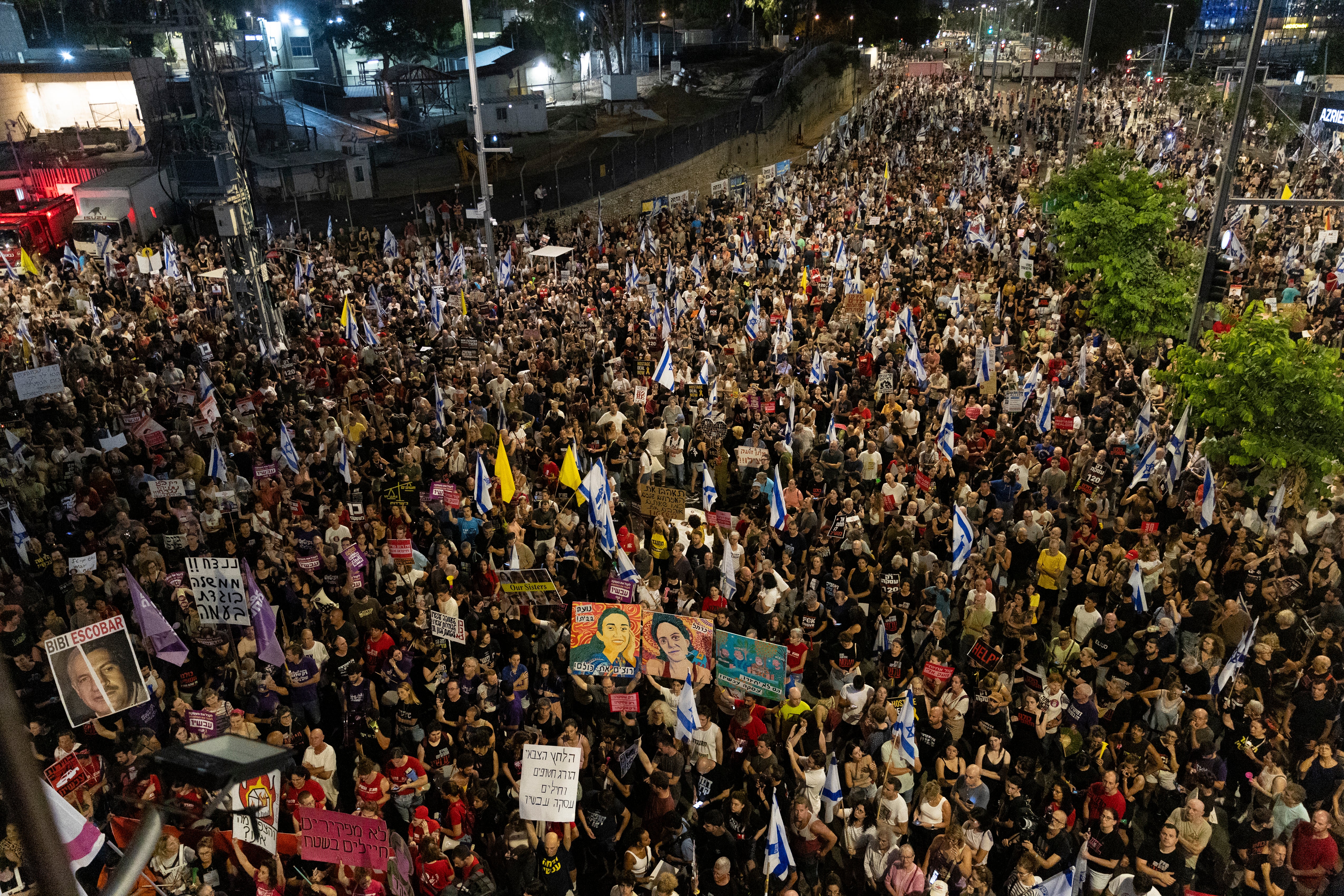 Protesters hold signs and flags during a demonstration calling for an hostages deal and against the Israeli Prime Minister Benjamin Netanyahu and his government in Tel Aviv