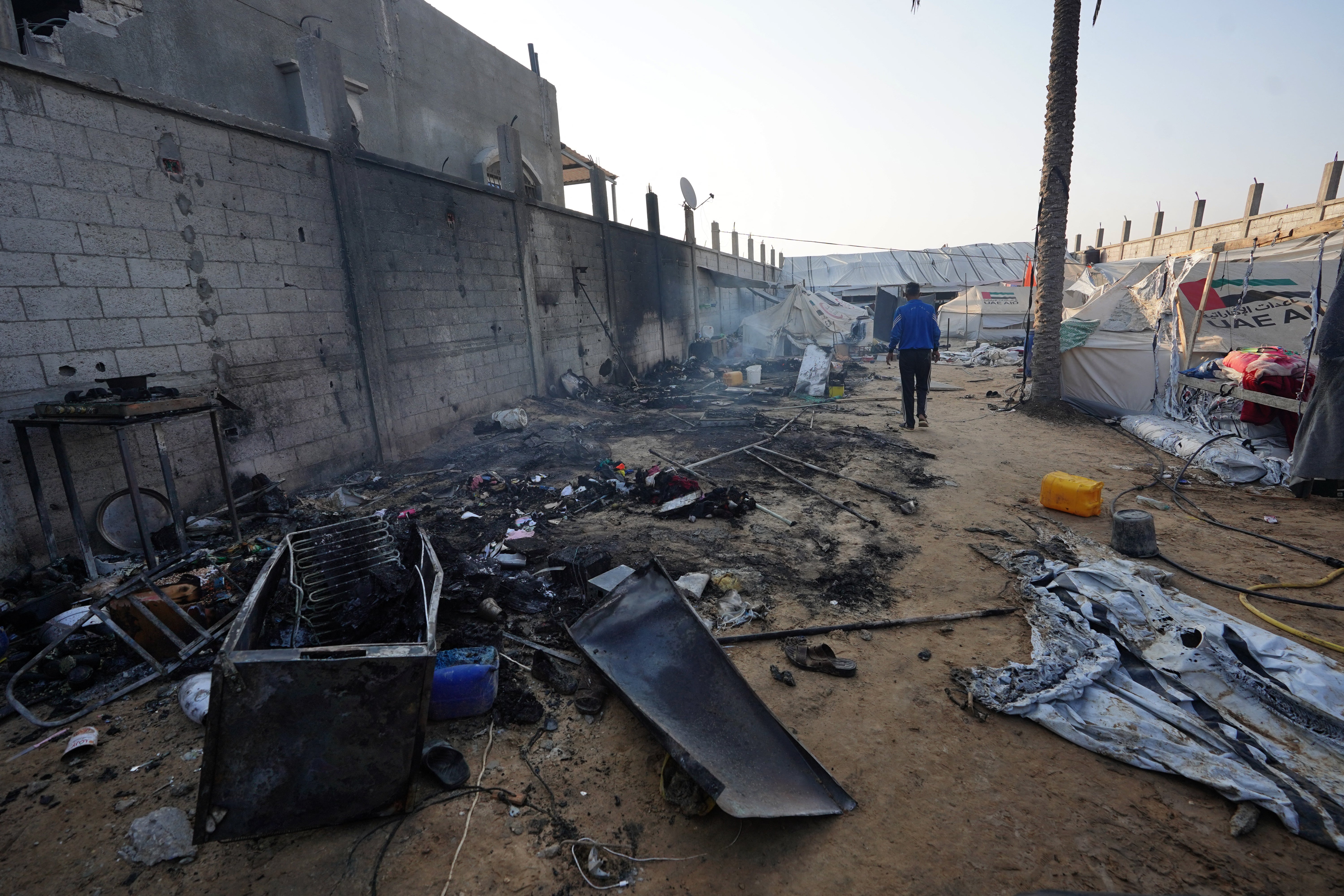 A man walks past destroyed tents the day after an Israeli strike in Mawasi near Rafah, Gaza