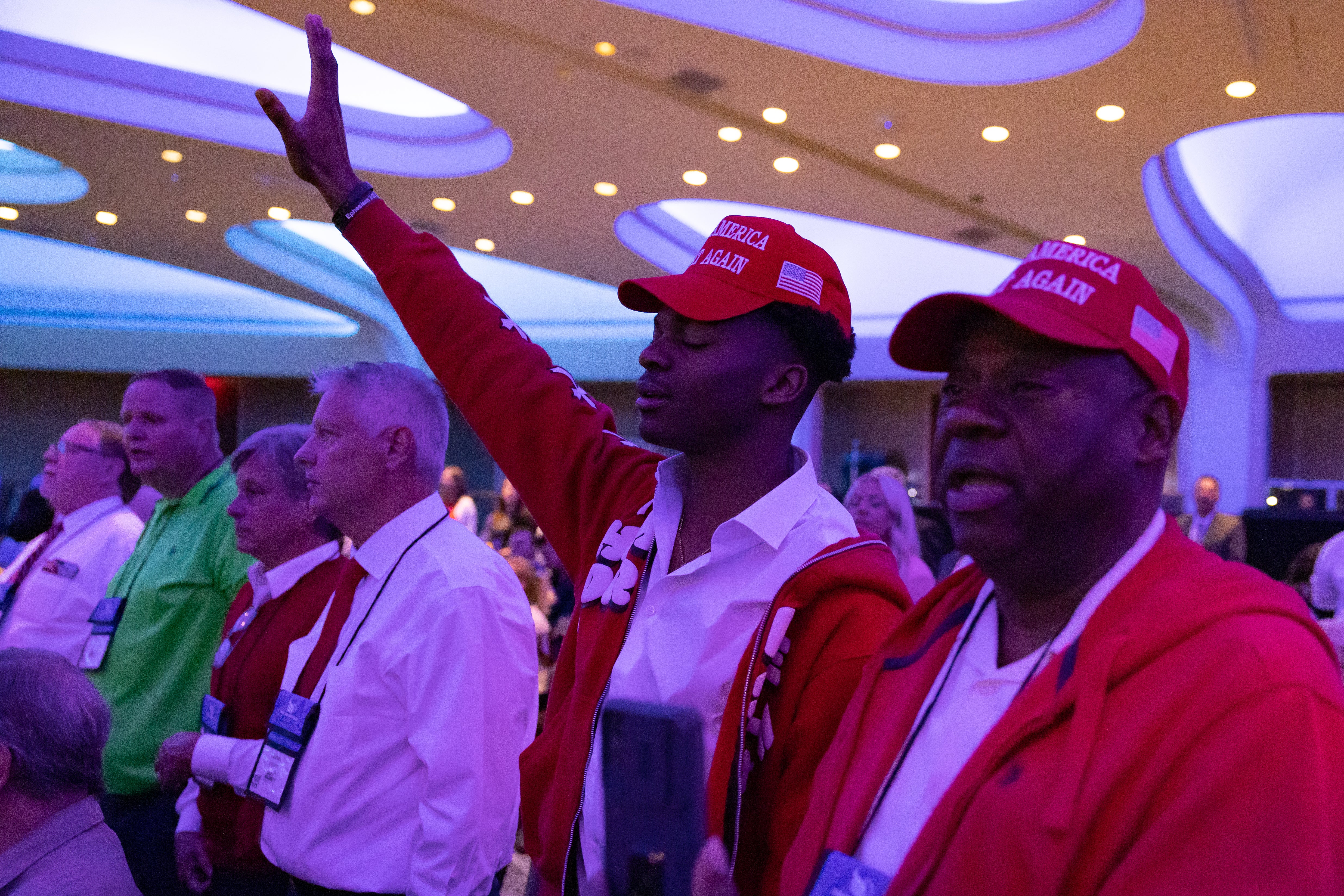 Frank Collins and his son pray at the conference. Collins says he acknowledges Trump isn’t a ‘perfect person’