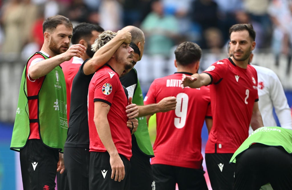 Saba Lobjanidze of Georgia is consoled by teammates