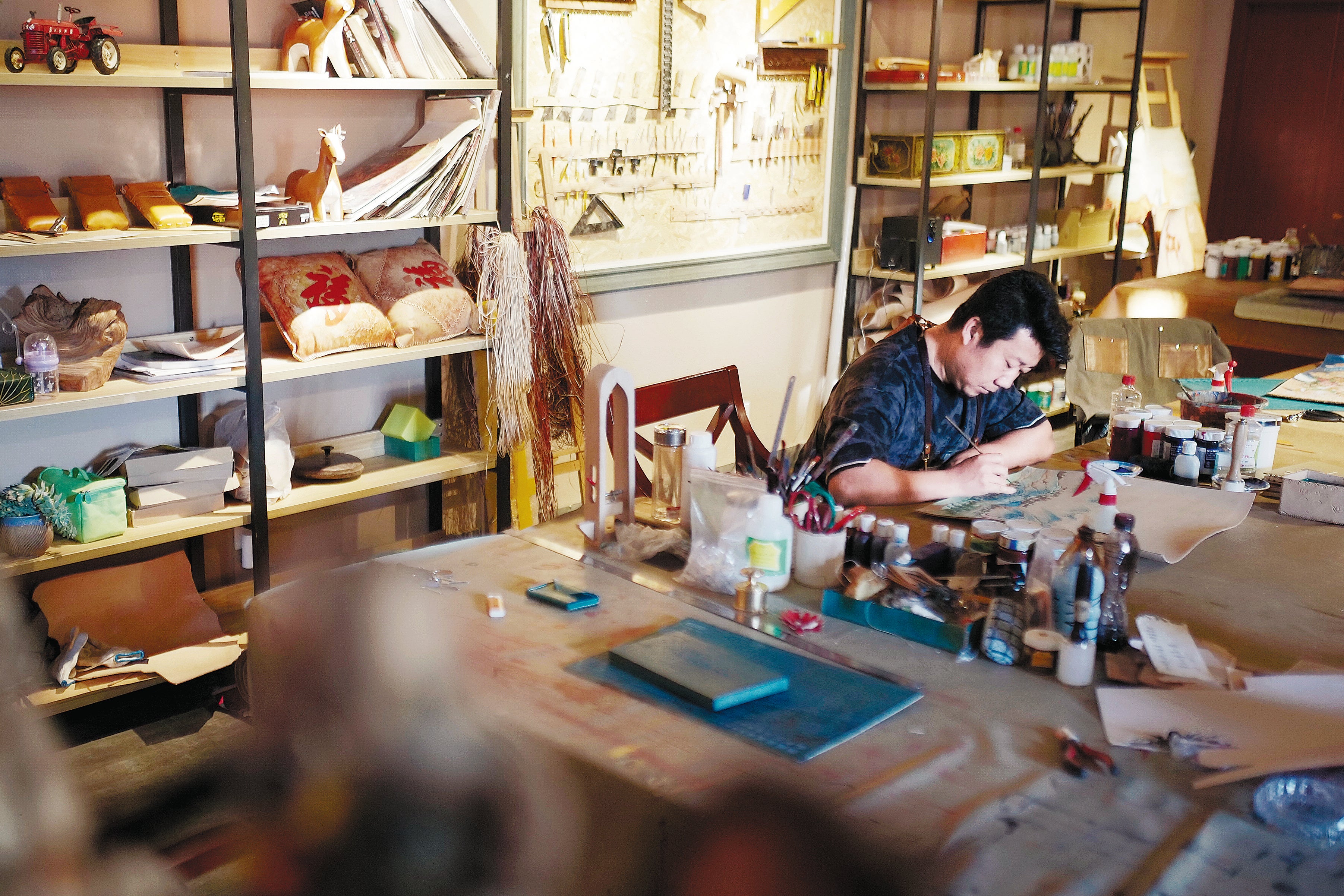 Jia Hongwei outlines a pattern to carve later at his art workshop in Hohhot, Inner Mongolia autonomous region