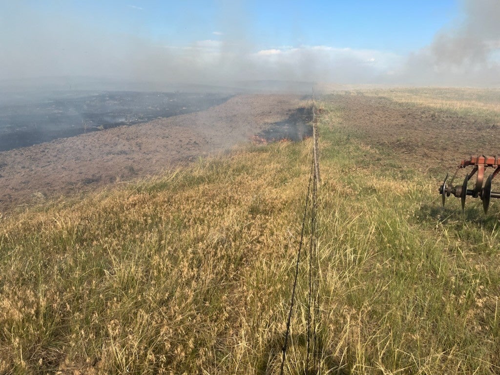 A fire smolders across the prairie near Richard Holtorf’s ranch in Colorado