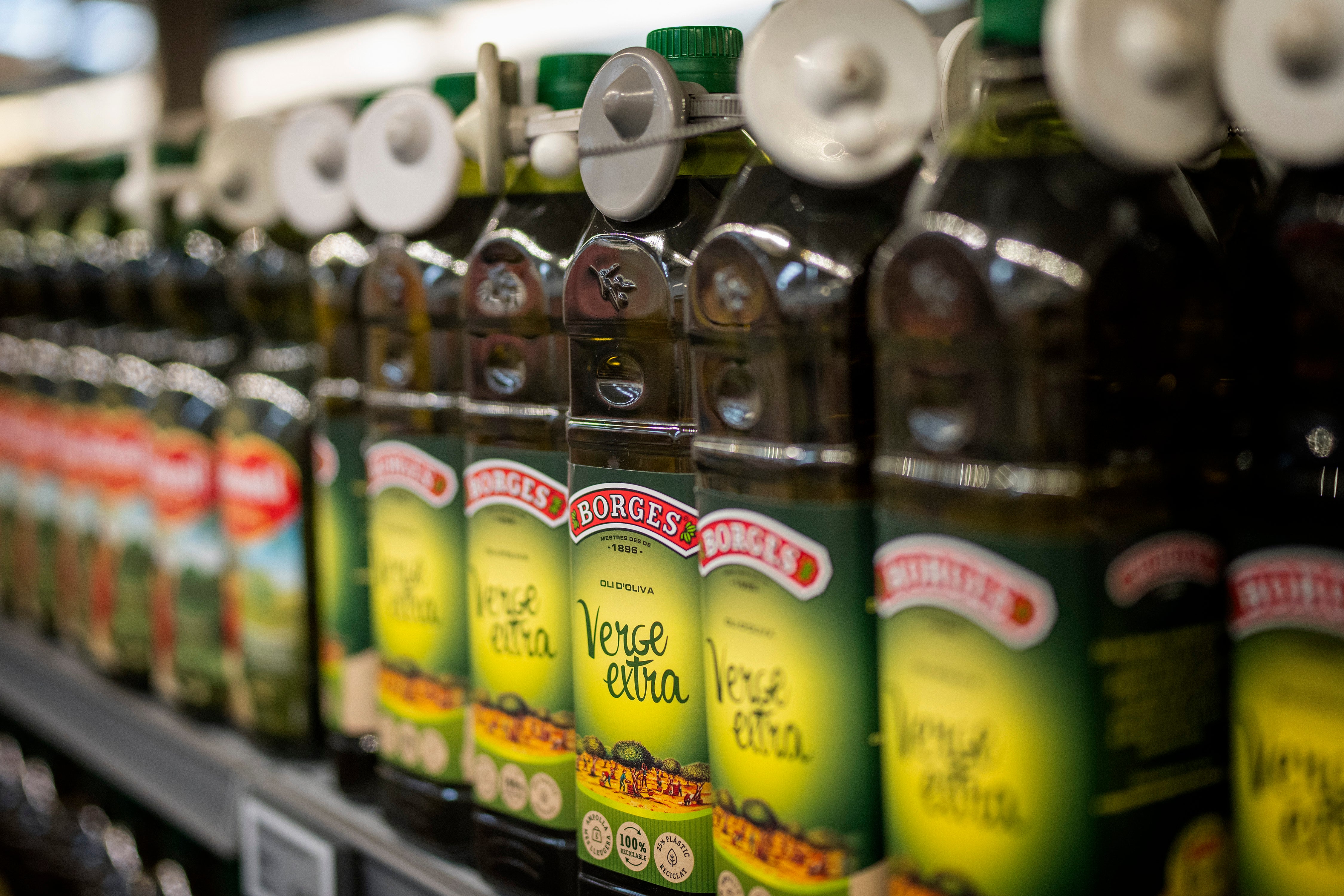 Bottles of virgin olive oil, sealed with an anti-theft system, are photographed on a shelf in a shop in Barcelona, Spain