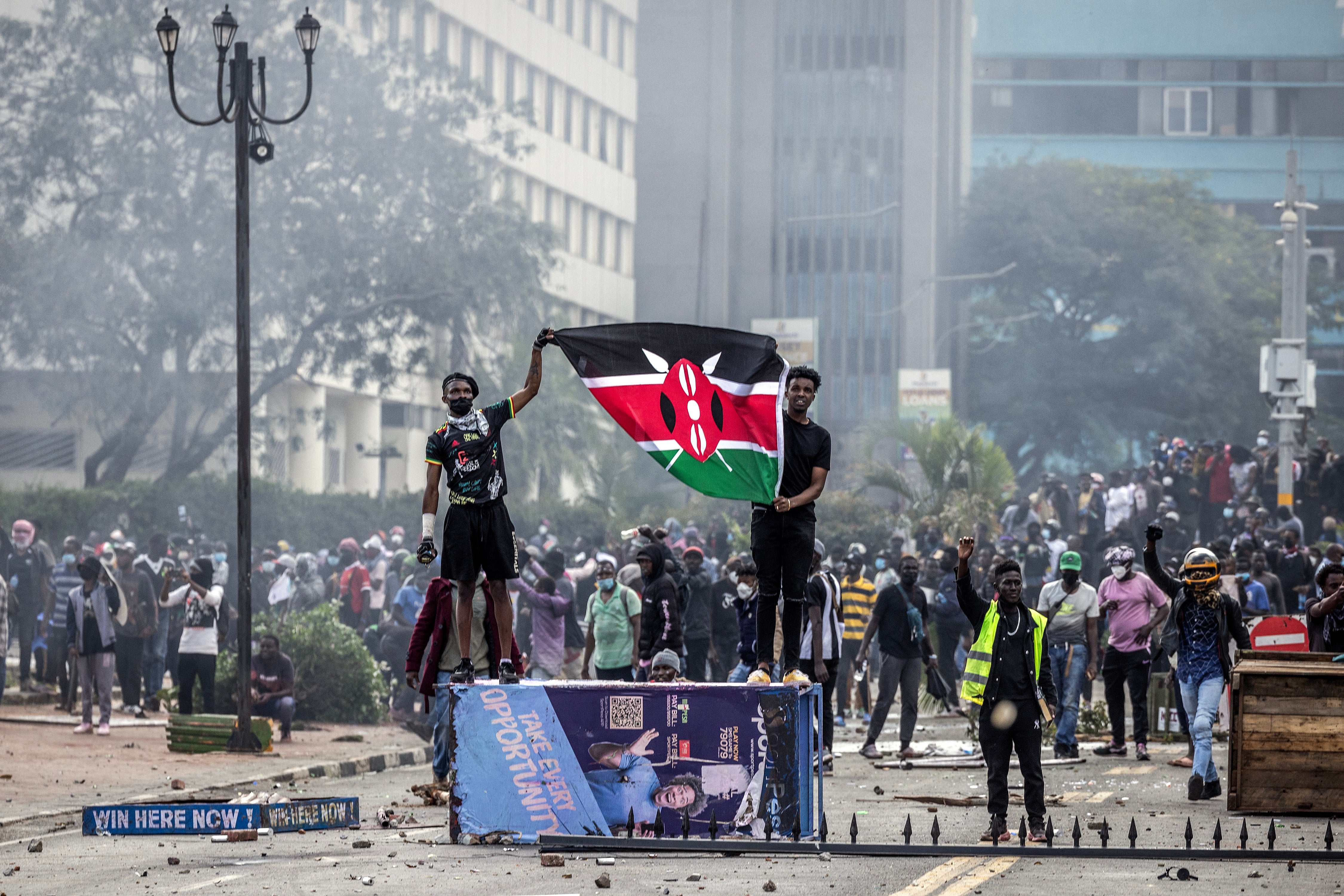 Protesters hold a Kenyan flag outside the Kenyan Parliament after storming the building during a nationwide protest against a tax bill