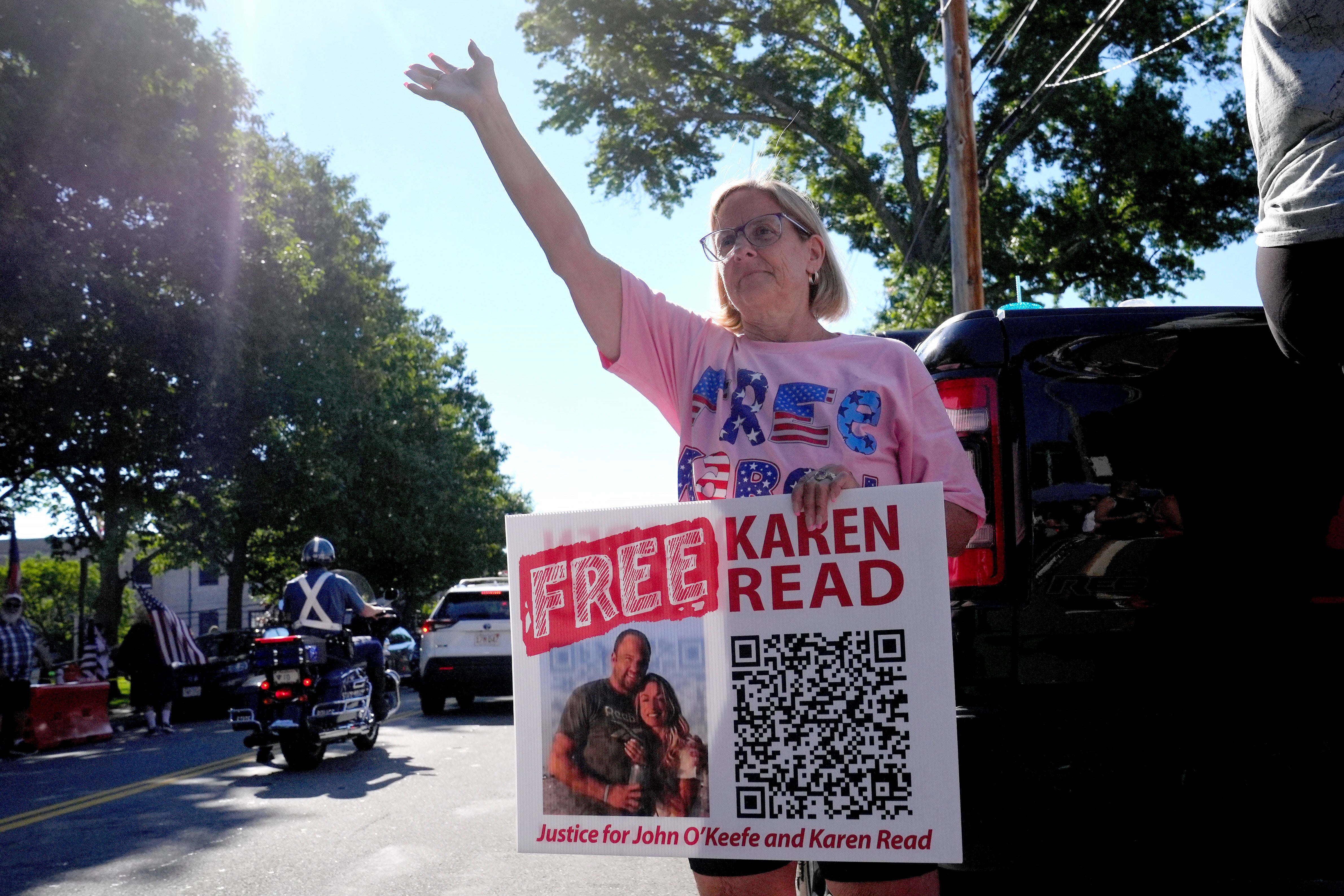 Laura McGillis, of Attleboro, Mass., a supporter of Karen Read, waves to passing cars a block away from Norfolk Superior Court