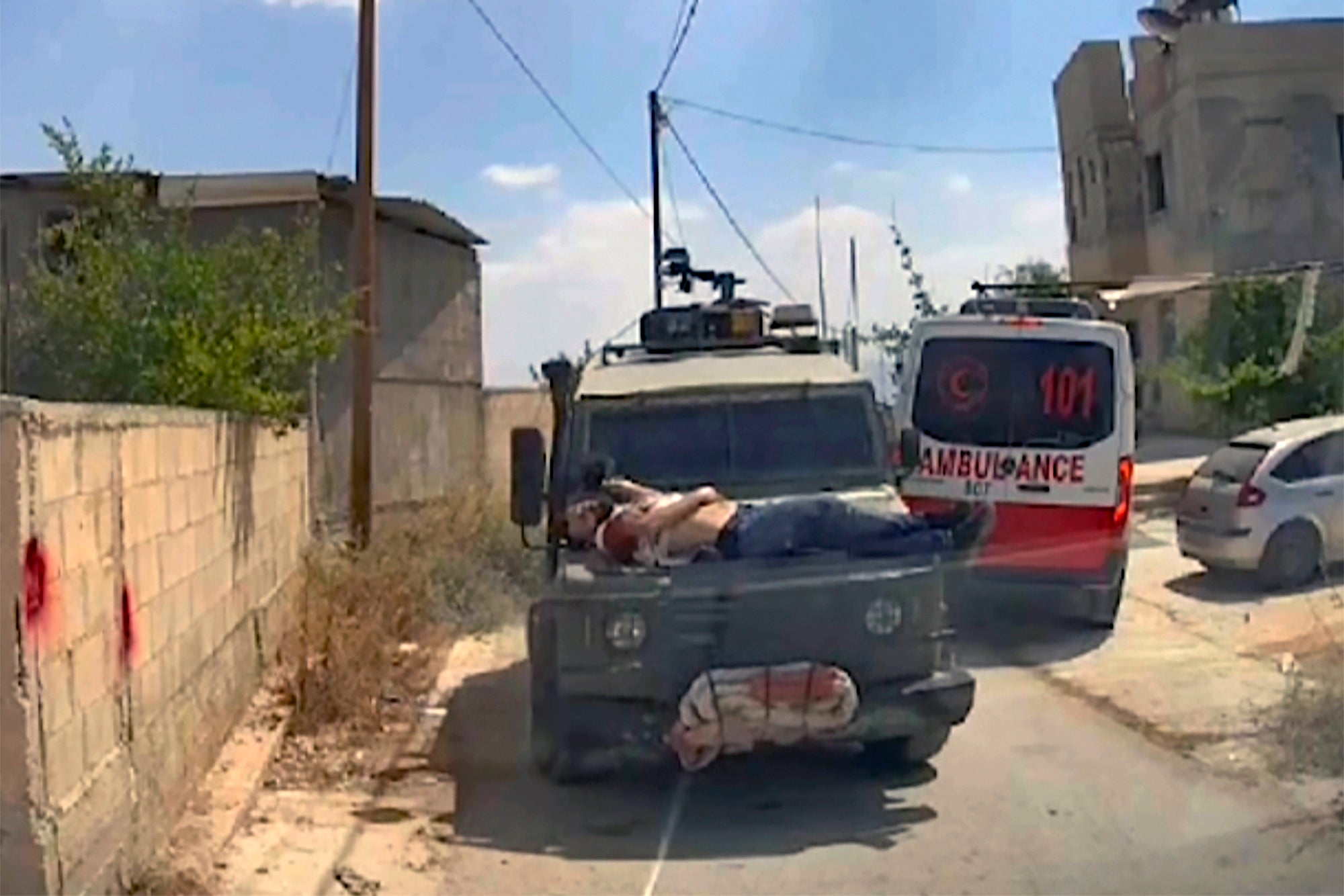 This image made from an ambulance dashboard camera video shows Mujahid Abadi, 24, bleeding from gunshot wounds on top of an Israeli military jeep in the West Bank city of Jenin, Saturday, June 22, 2024