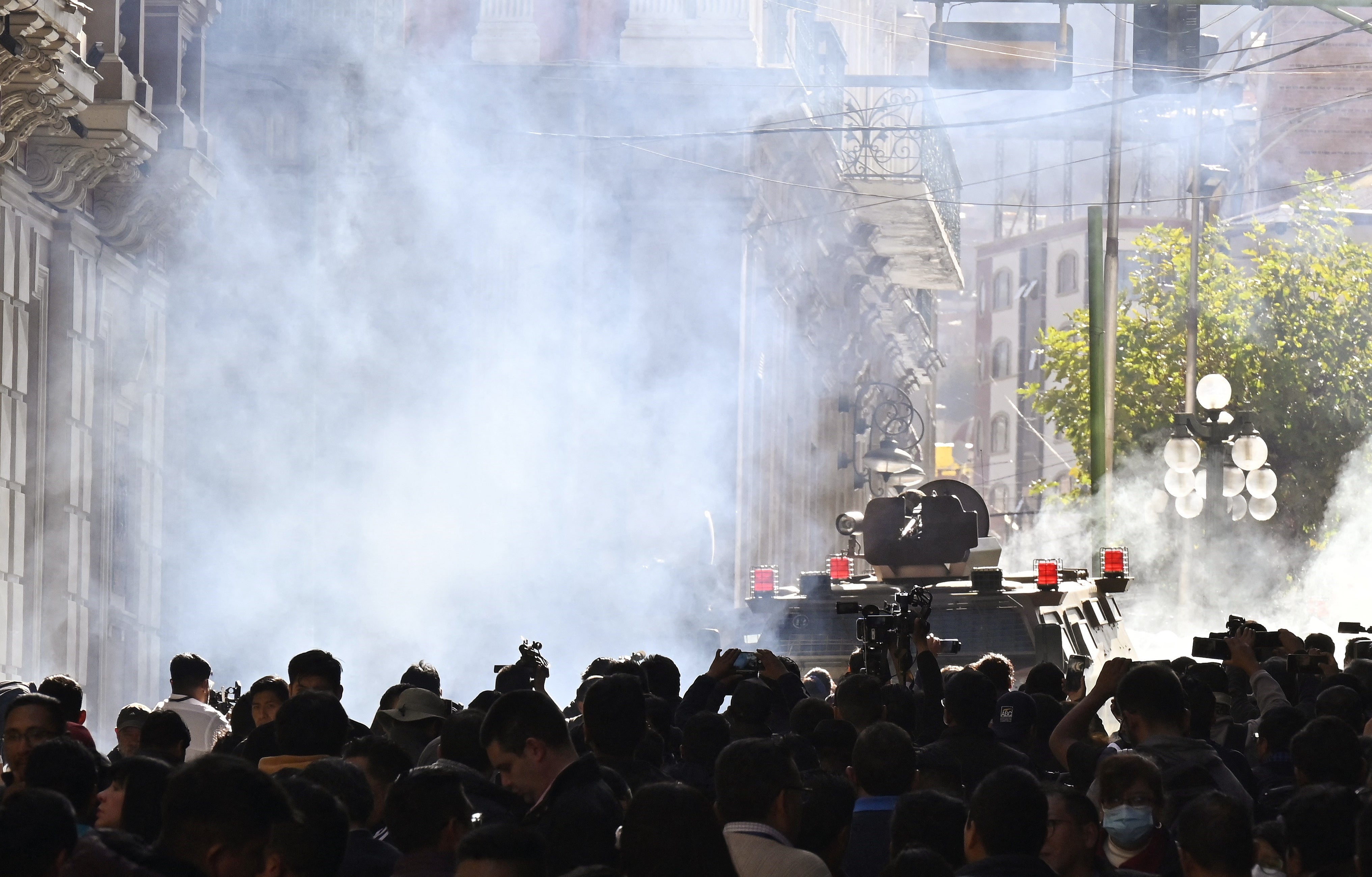 Military troops in armored vehicles fire tear gas at people outside the Quemado Palace at Plaza Murillo in La Paz on June 26, 2024