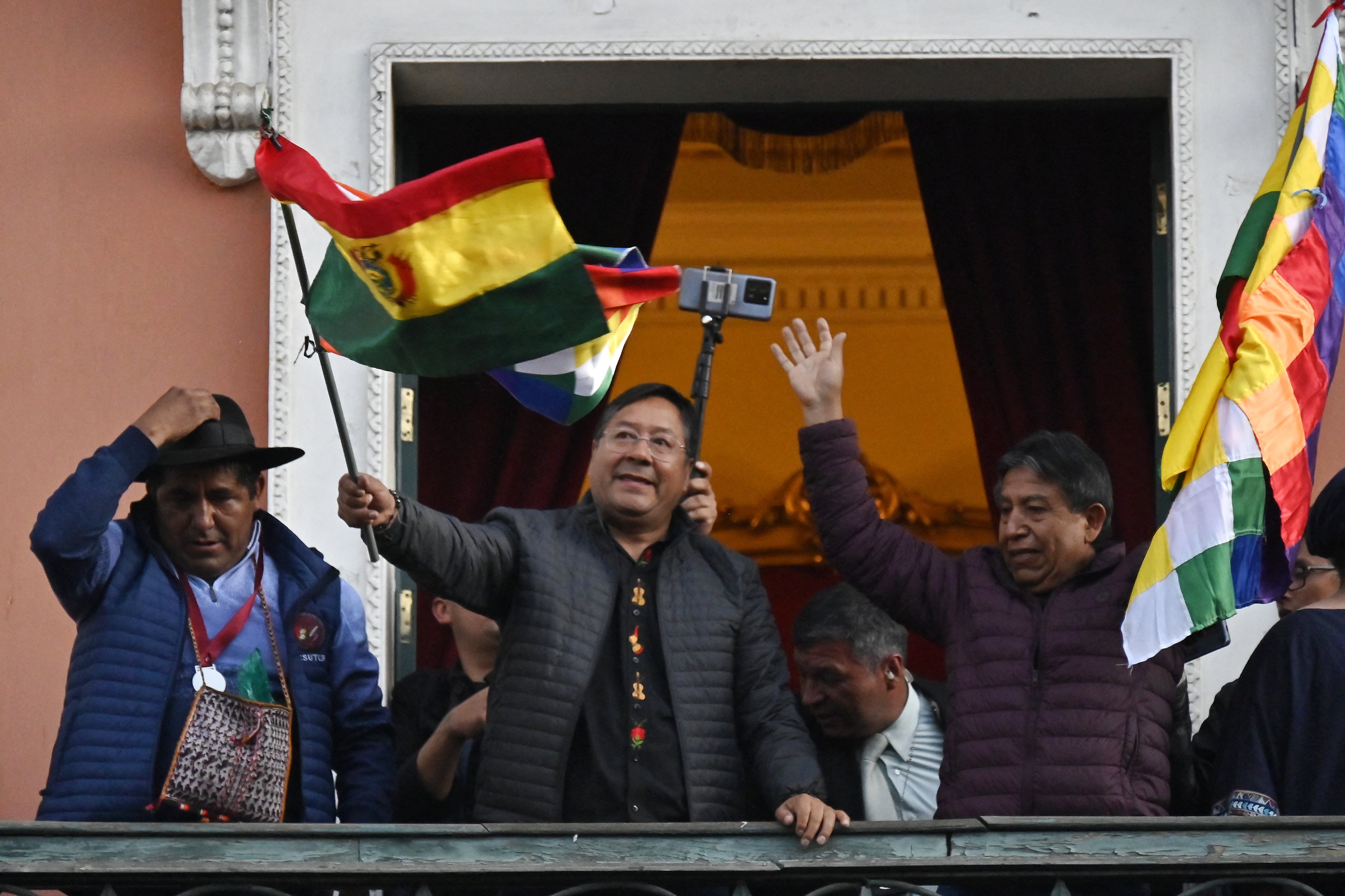 Bolivian President Luis Arce waves a Bolivian flag at the balcony of the Government Palace in La Paz