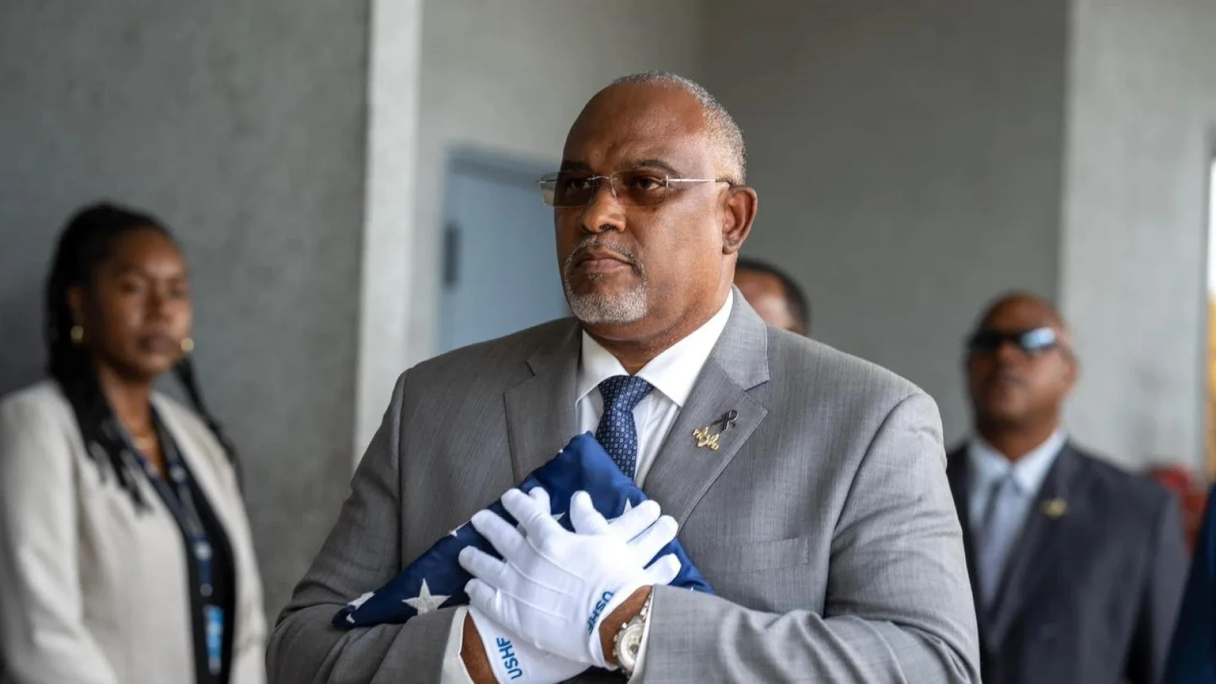 Ray Martinez, who has resigned as police commissioner after being implicated in an ongoing federal investigation, holds the US Honor Flag