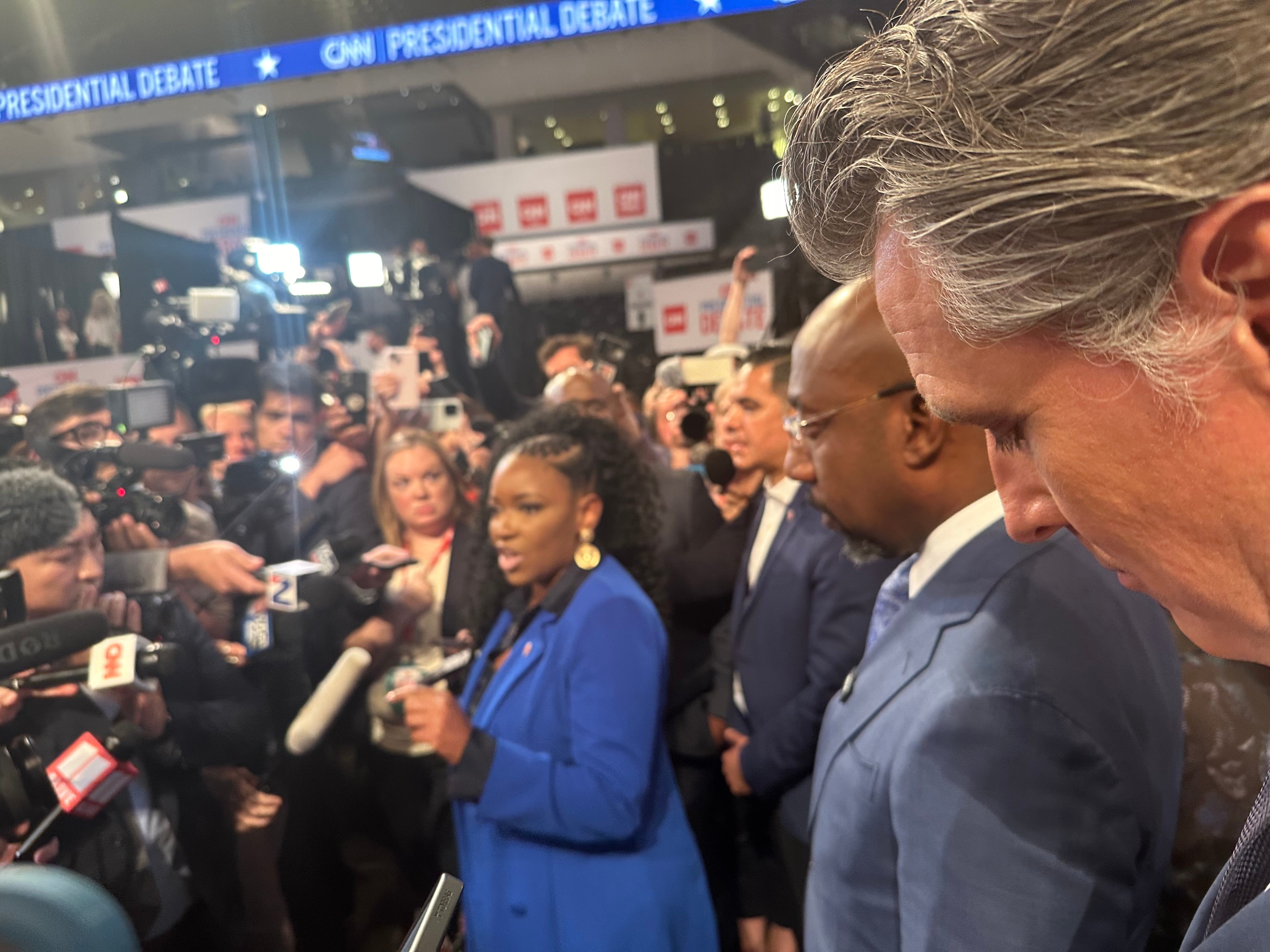 Rep Jasmine Crockett speaks as Senator Raphael Warnock and Gavin Newsom look on. Newsom said that he ‘would never turn [his] back’ on President Biden