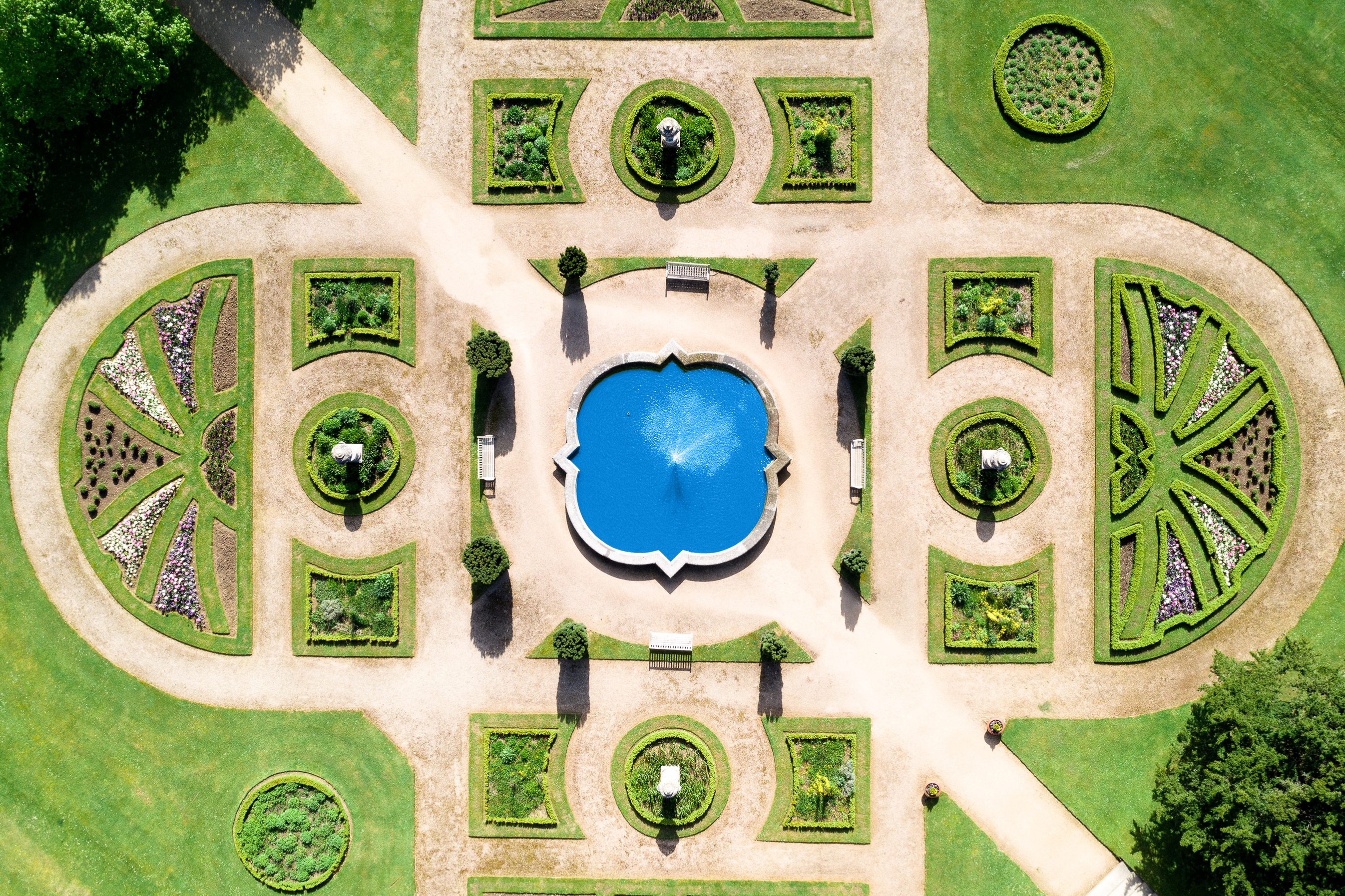 Eight rose beds are arranged around the historic central fountain