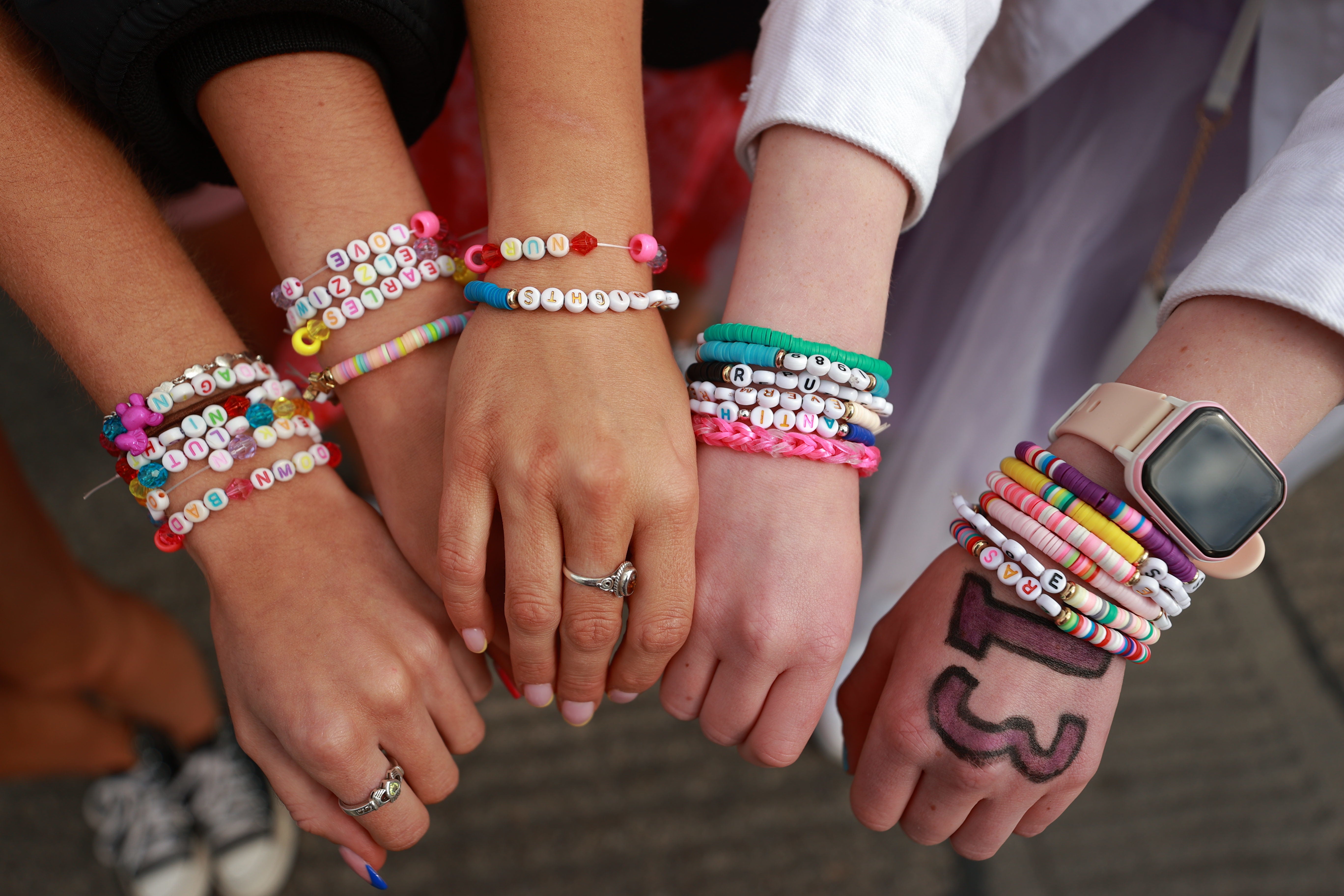 Sisters from Cork, Ireland show their friendship bracelets before watching Taylor Swift performing on stage at the Aviva Stadium in Dublin