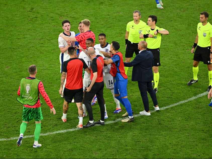 Rice is led away after being shoved by the Slovakia manager