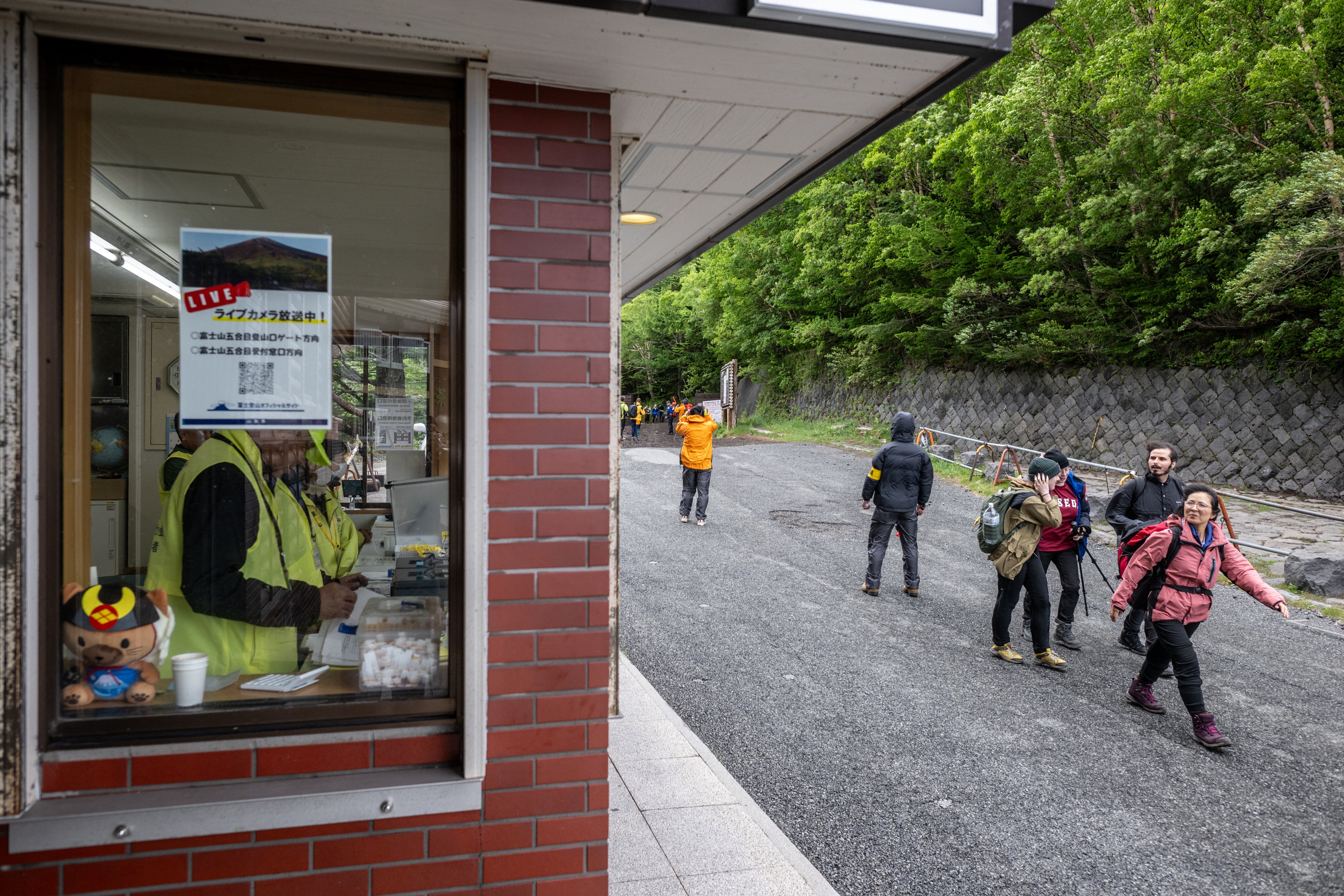 Hikers walk past the administration centre of Fuji Subaru Line 5th station at Narusawa in Yamanashi prefecture