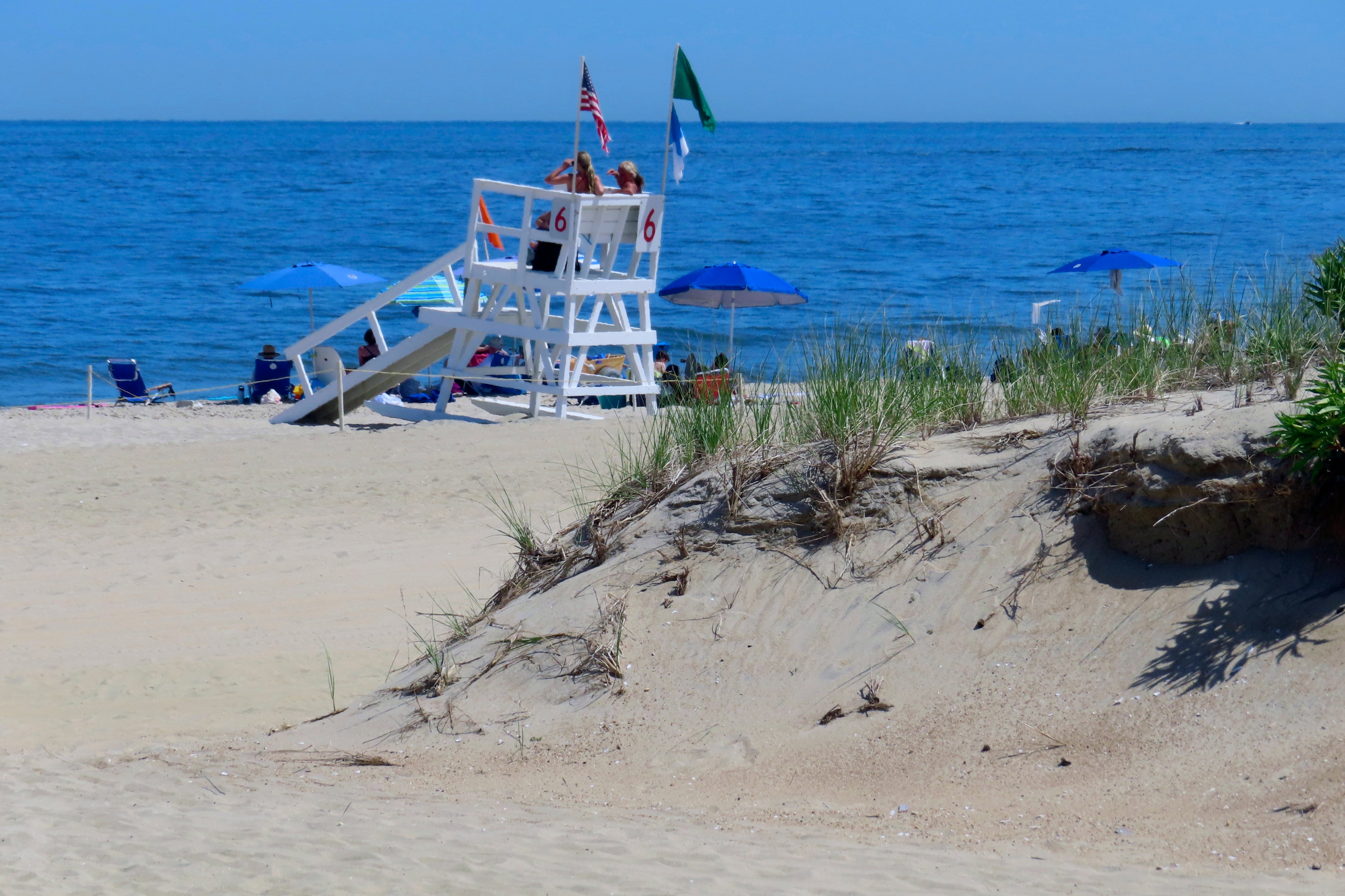 A beach in New Jersey. A lifeguard in New Jersey was injured after an umbrella pierced through her shoulder. She was taken to a local hospital for treatment following the incident