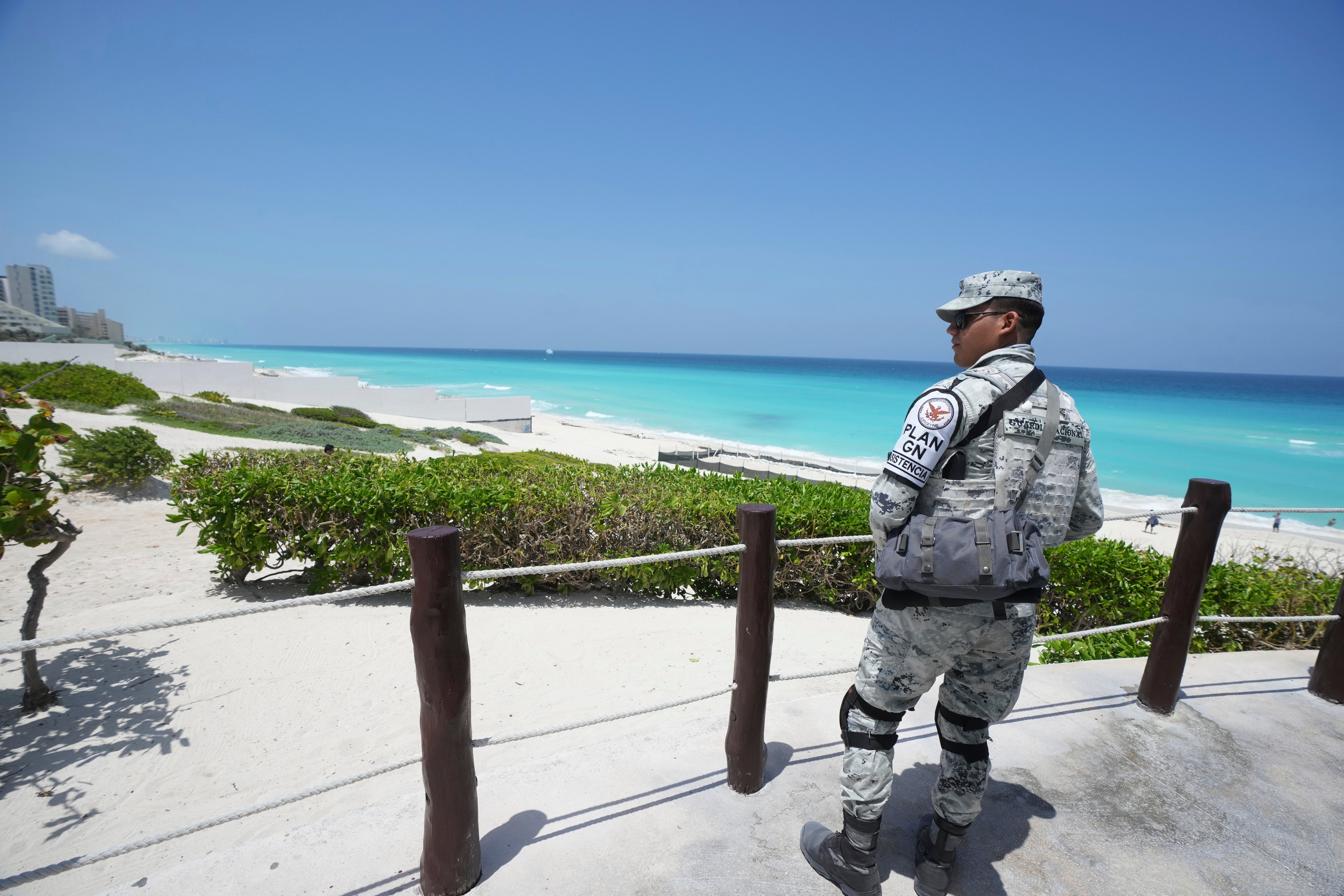 A Mexican soldier stands guard on a beach in Cancun, Mexico