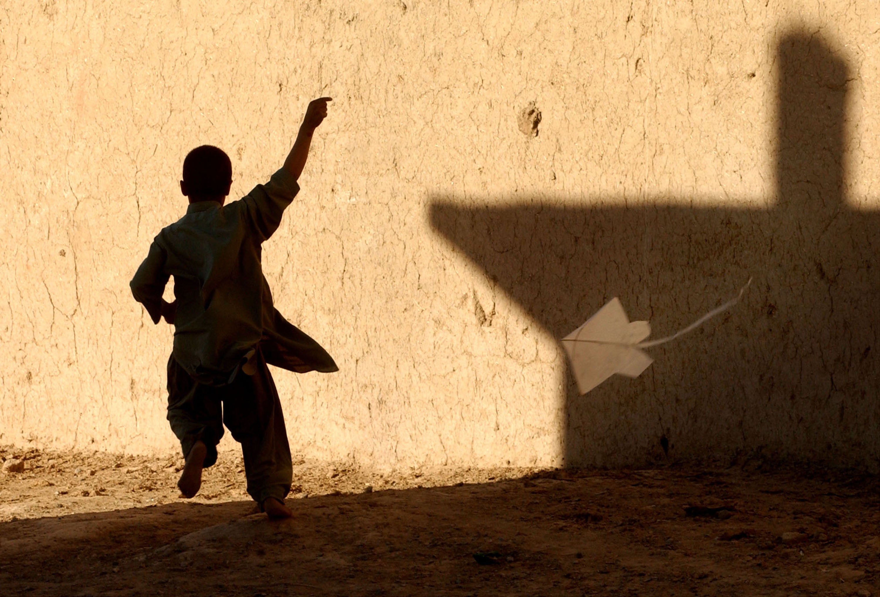 A young Afghan boy flies a kite in a refugee district of Quetta, Pakistan