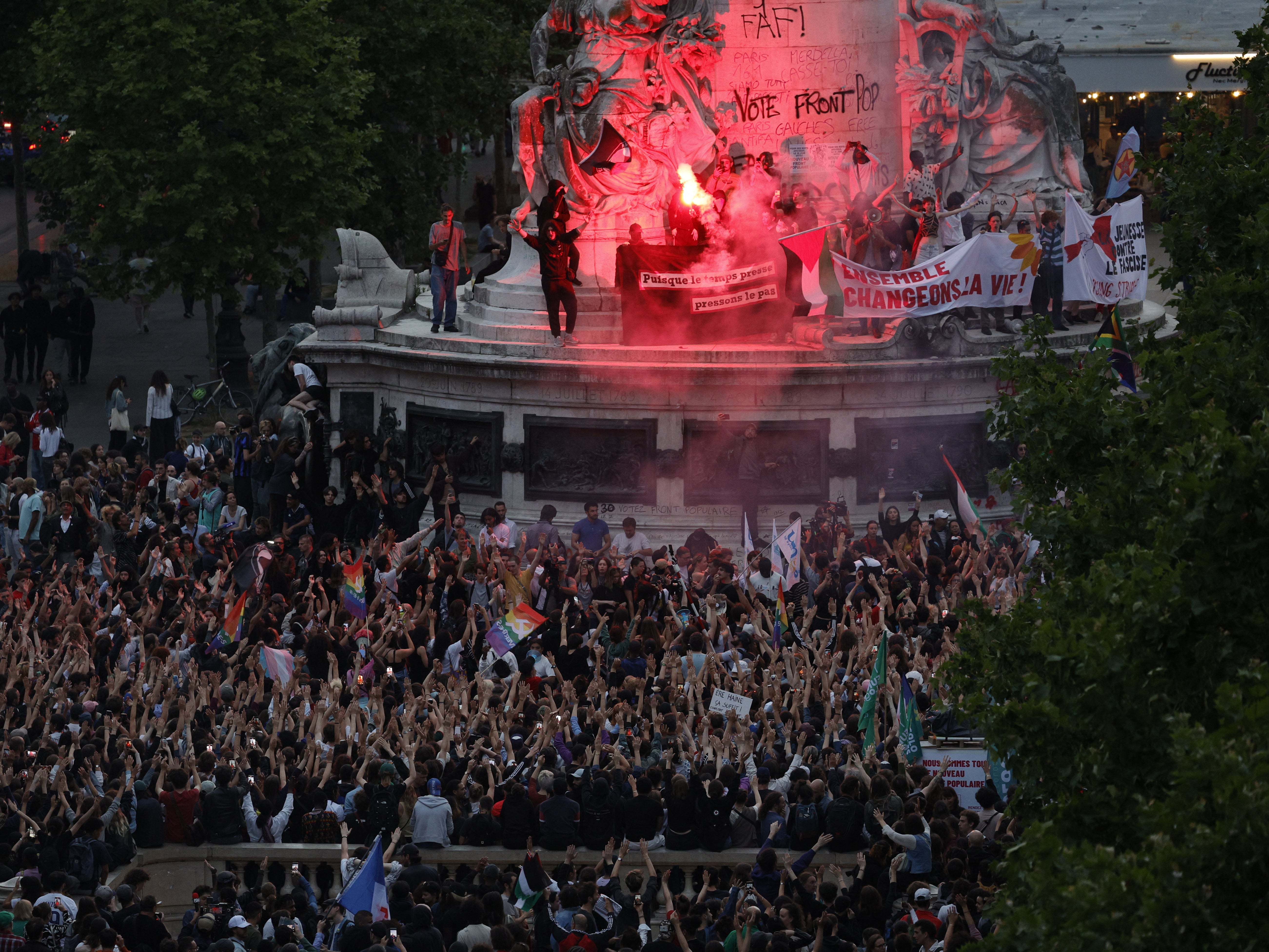 Demonstrators standing on the Monument a la Republique after the first round of parliamentary elections