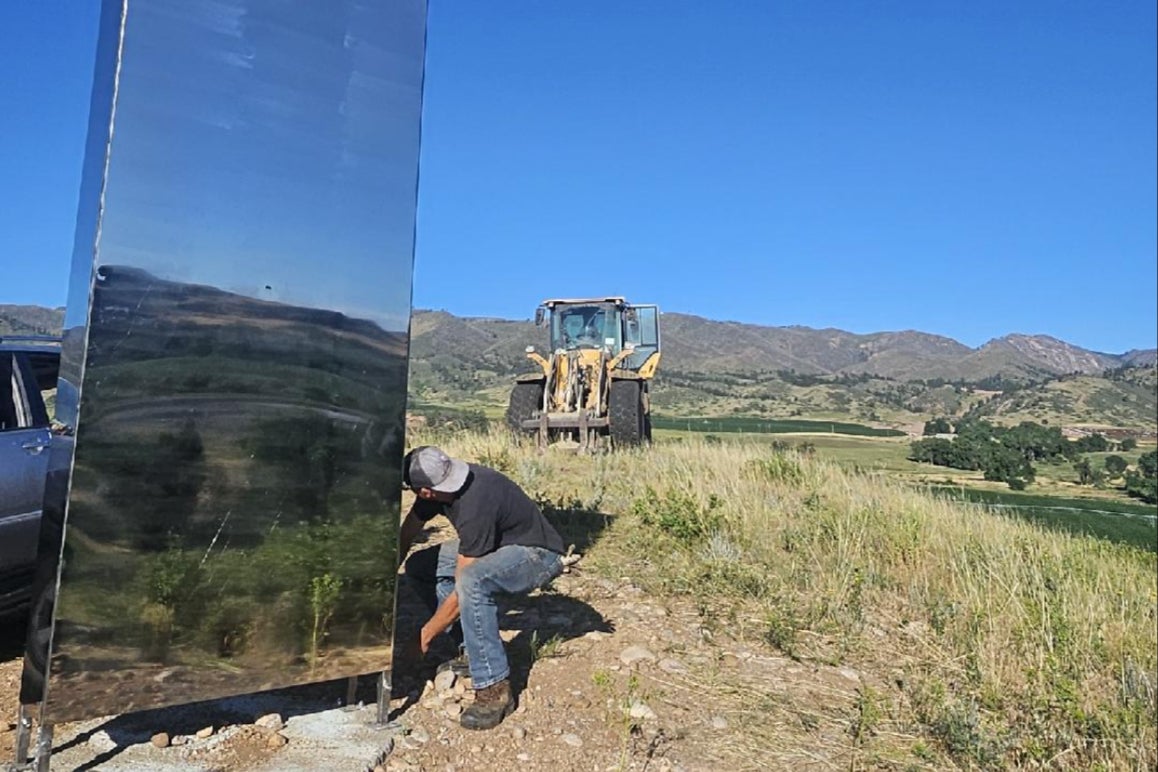 Pictures showed the tall, shiny, rectangular object being unbolted by workers and removed with a tractor and forklift