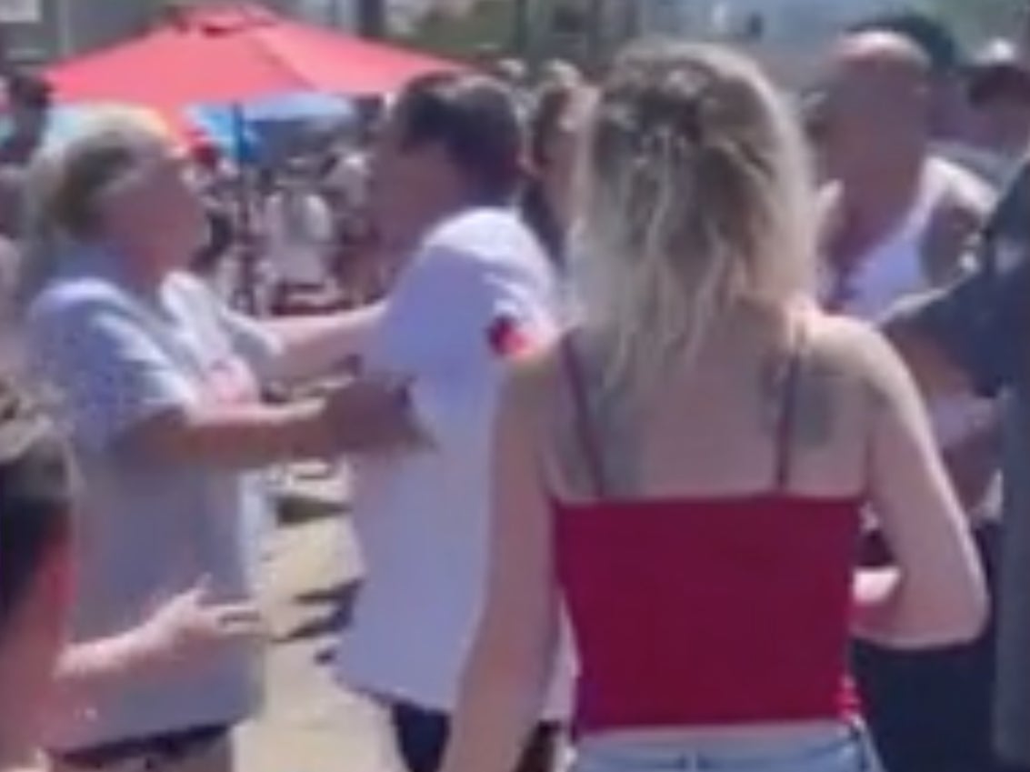 A woman at a Los Angeles Fourth of July parade tries to hold actor Danny Trejo back after he tried to punch a man who threw a water balloon at him