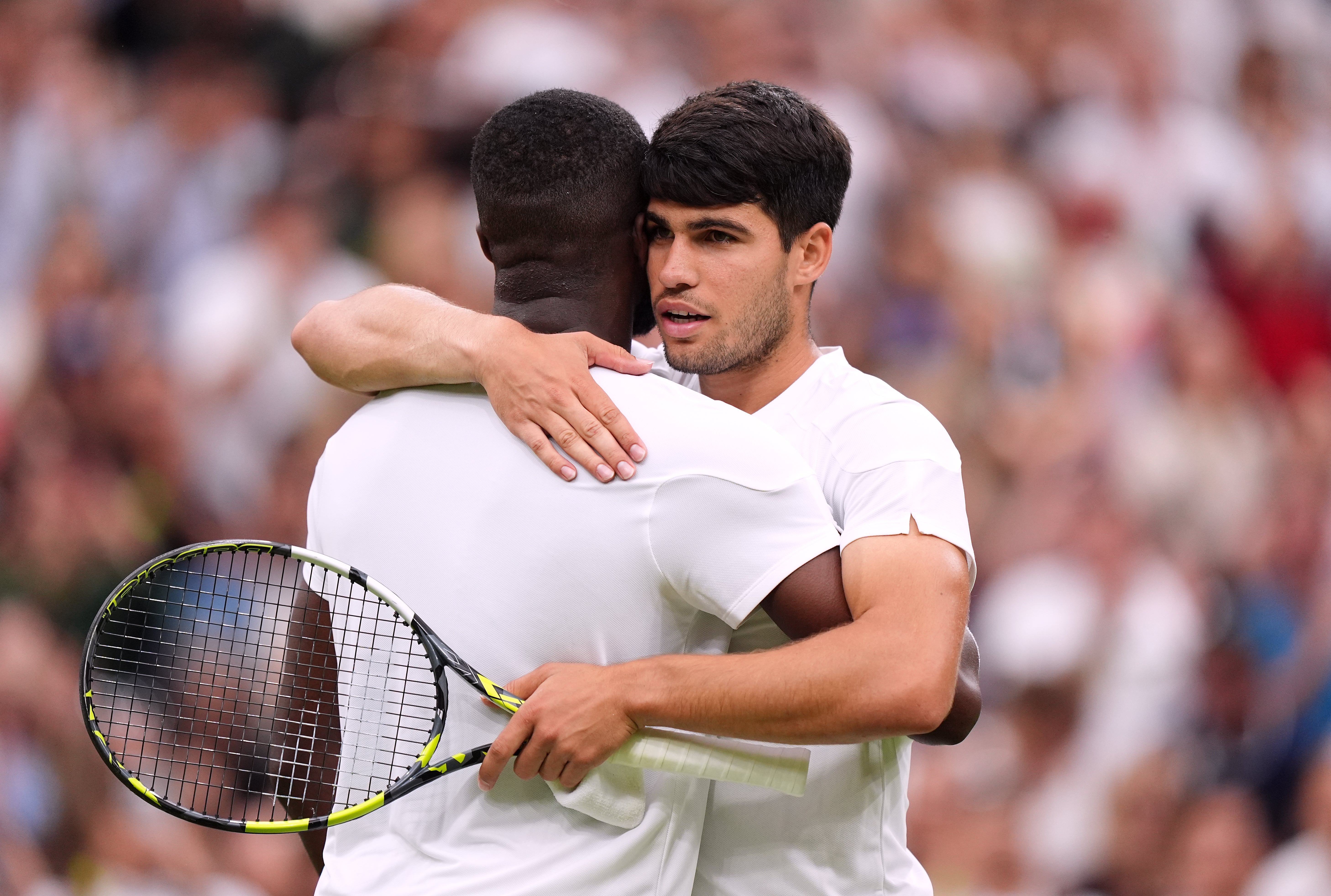 Carlos Alcaraz embraces Frances Tiafoe at the net after their match