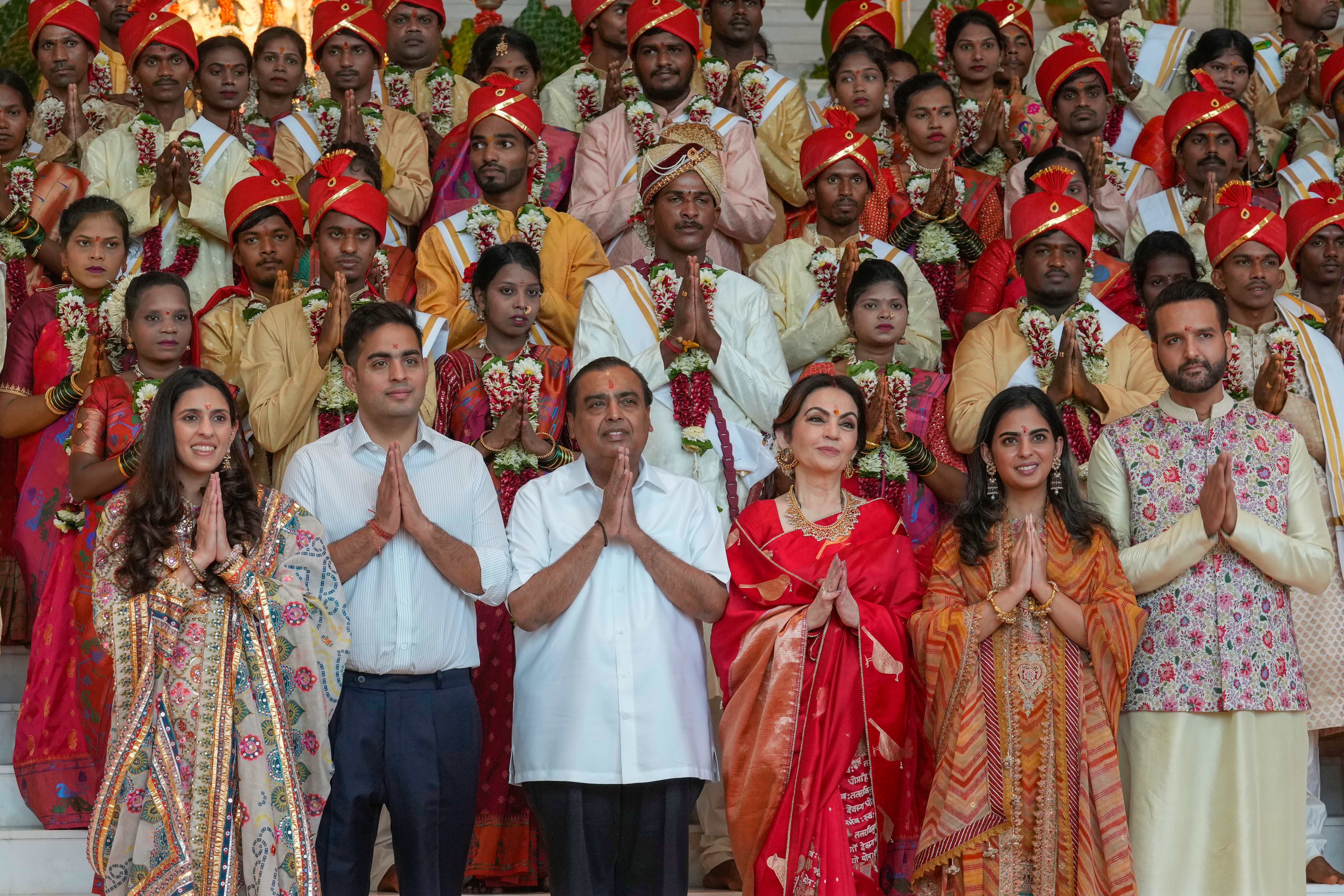 Mukesh, third left, poses with his family members and underprivileged couples during a mass wedding organised as part of the pre-wedding celebrations for his youngest son Anant, on 2 July