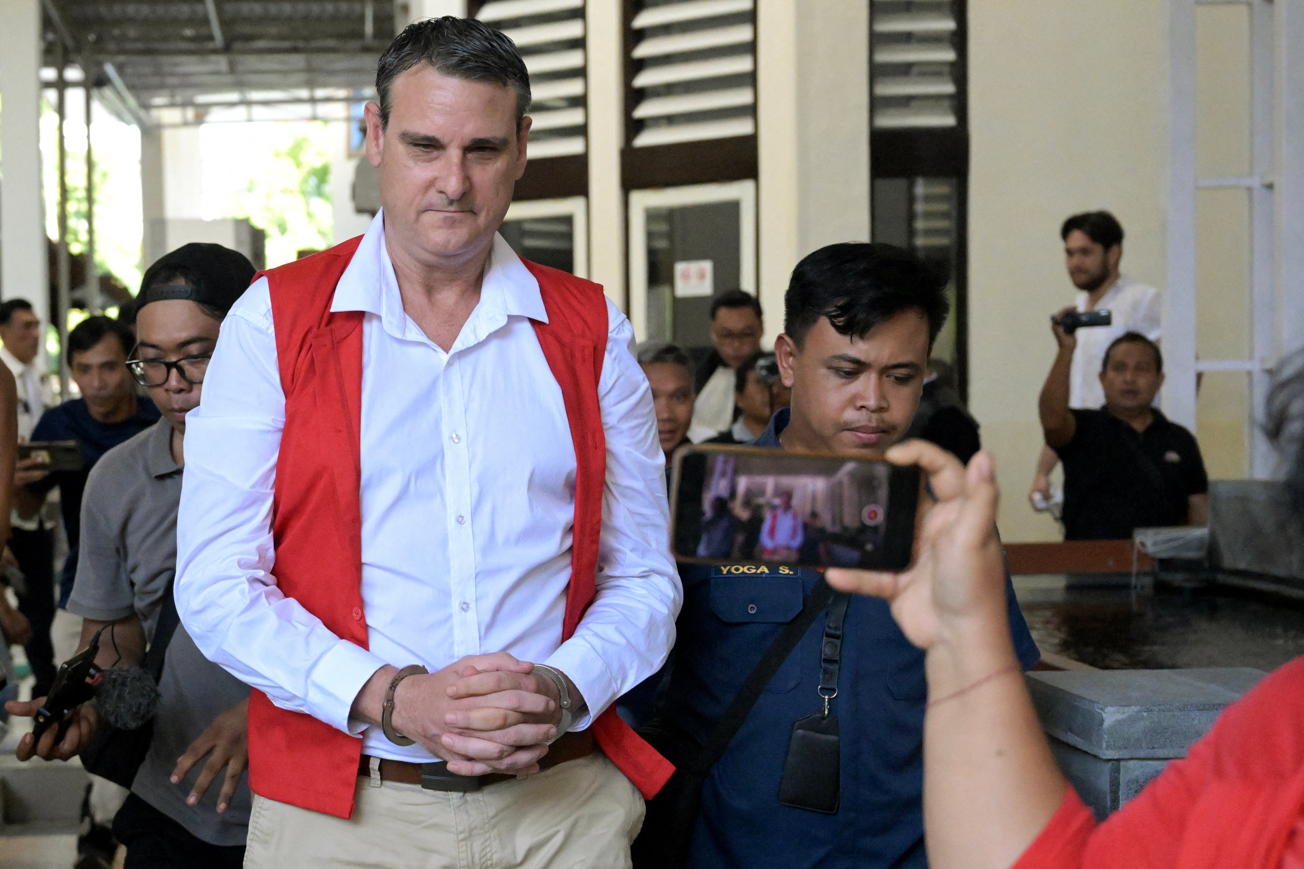 Australian Troy Smith (C) leaves after attending a court hearing as part of his trial in Denpasar on Indonesia’s resort island of Bali on June 13