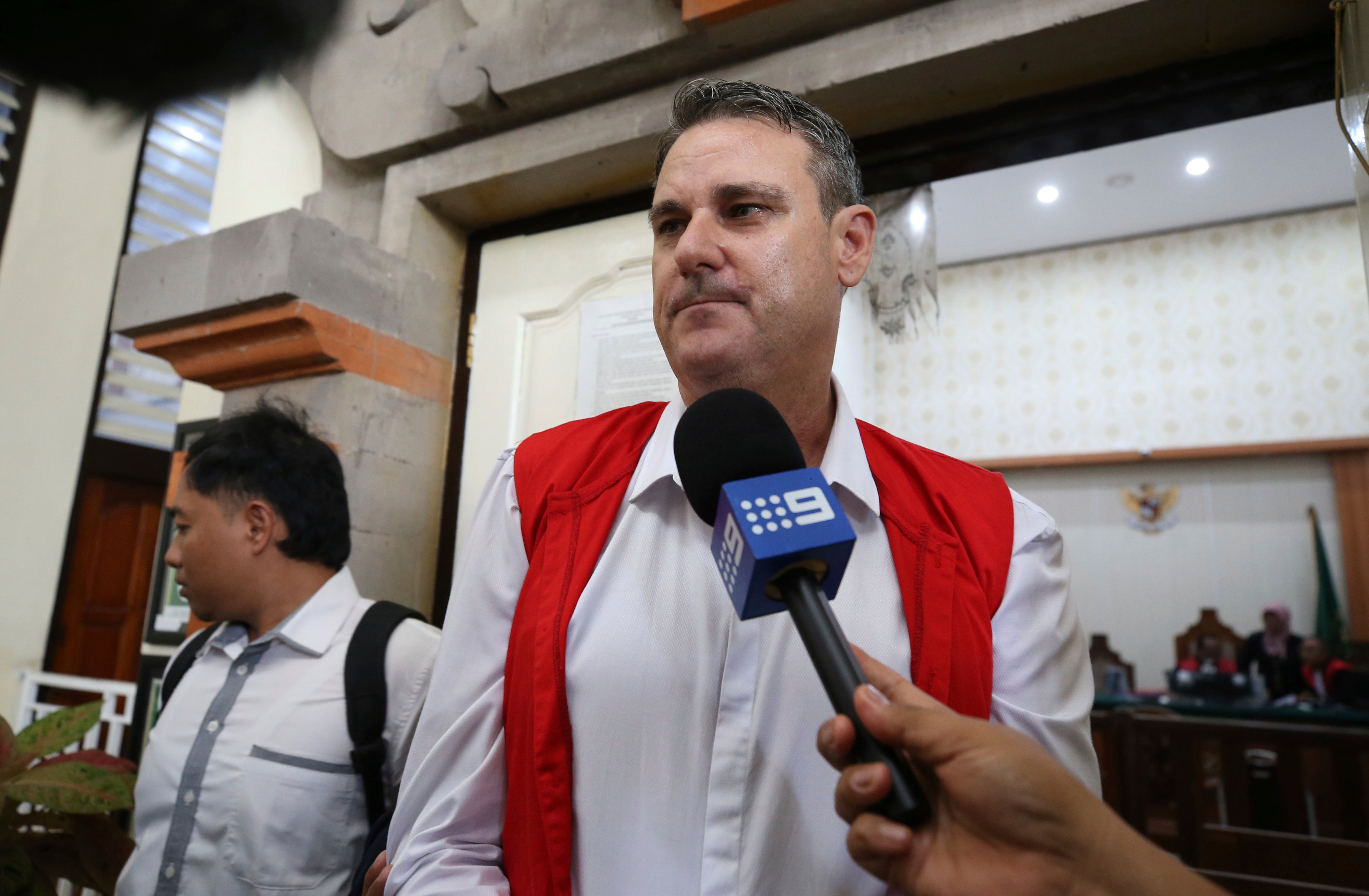 Australian Troy Smith, right, walks after his verdict trial at Denpasar district court in Bali, Indonesia on Thursday, July 4