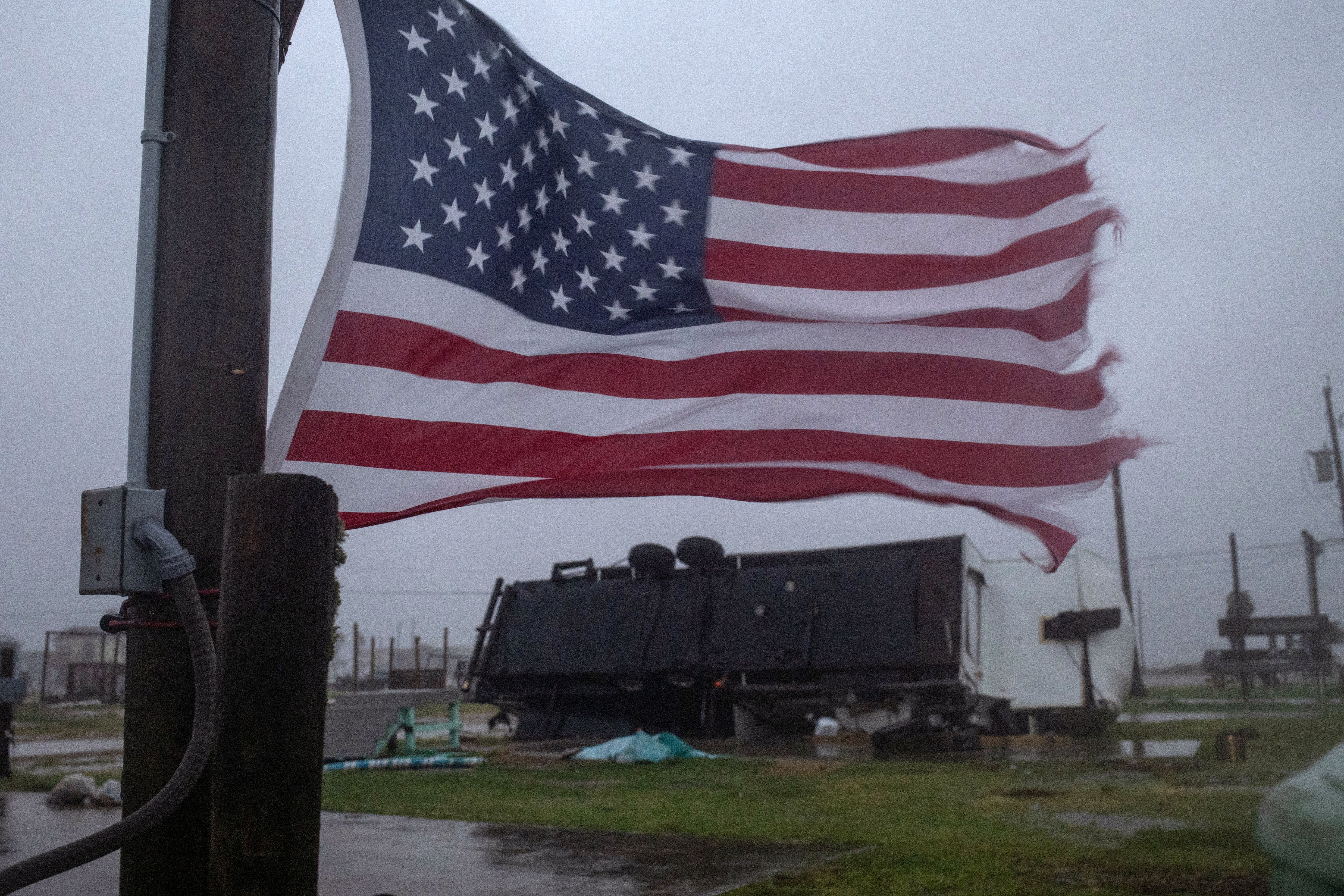 An American flag waves near a trailer home left overturned by Hurricane Beryl winds in Surfside Beach, Texas on July 8. A 53-year-old man died in the storm when a tree hit his home in Humble, Texas