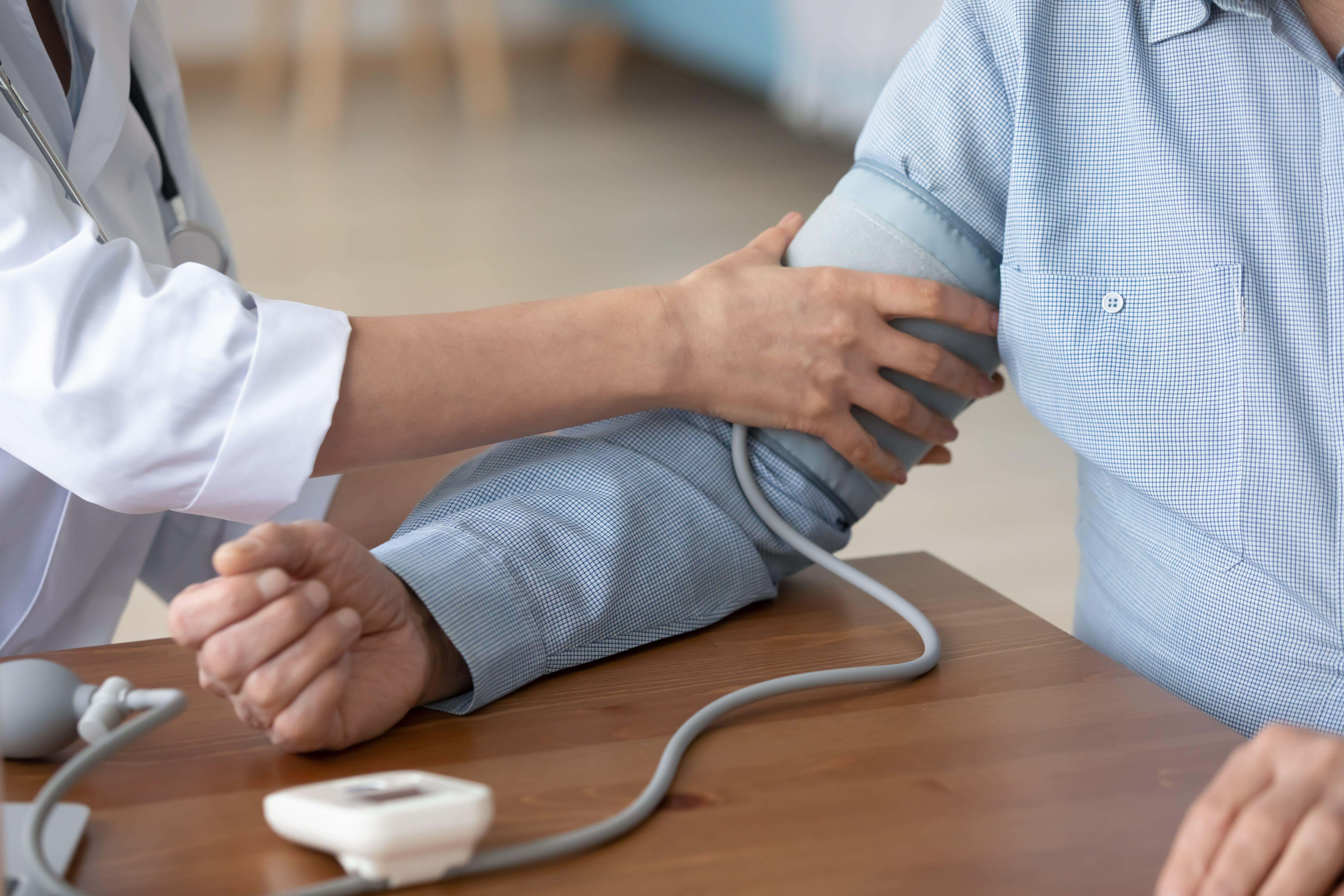 A nurse measure a patient’s blood pressure with a monitor