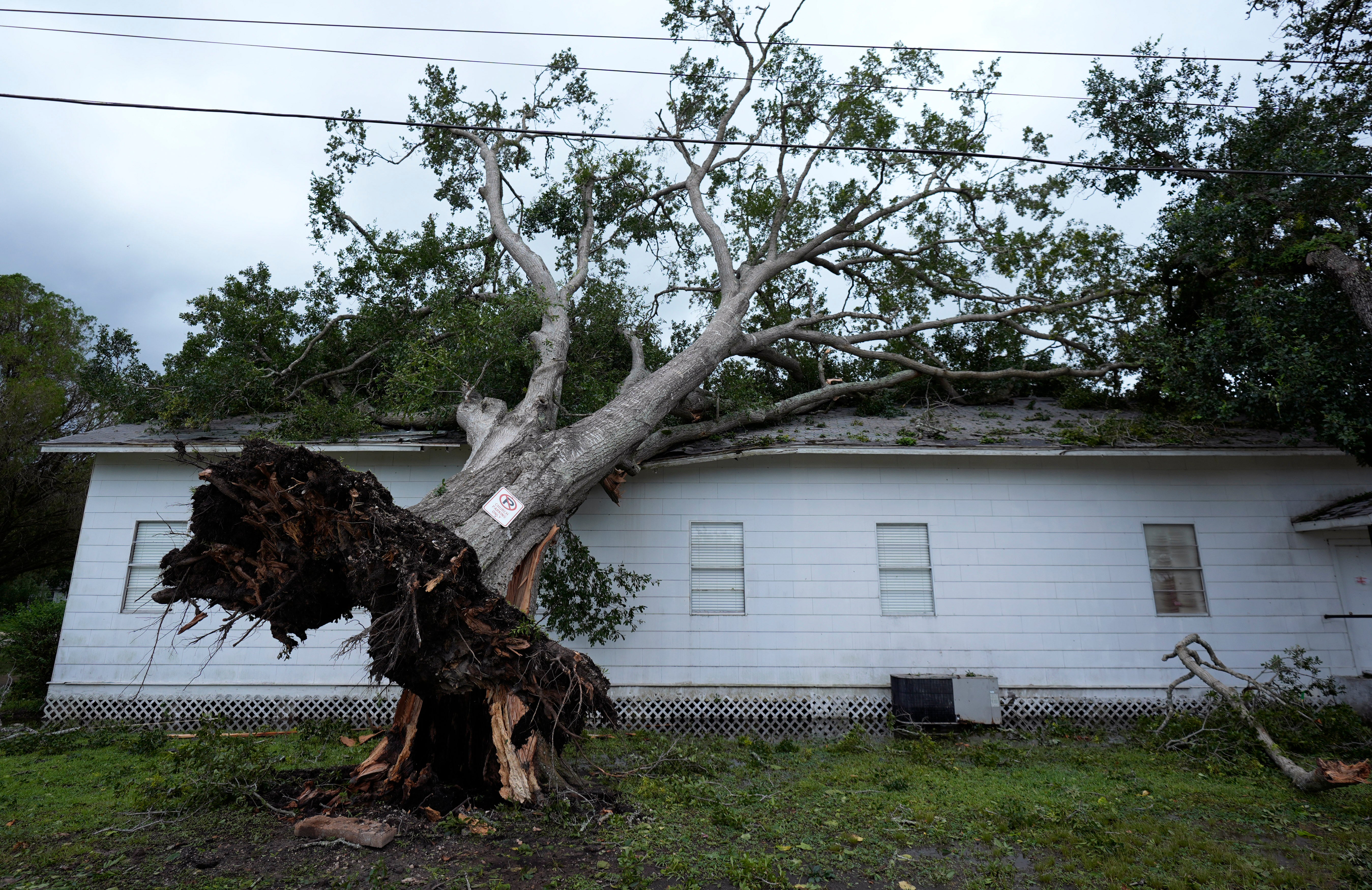 An upended tree rests on Bethel Church after Hurricane Beryl moved through the area, Monday, July 8, 2024, in Van Vleck, Texas