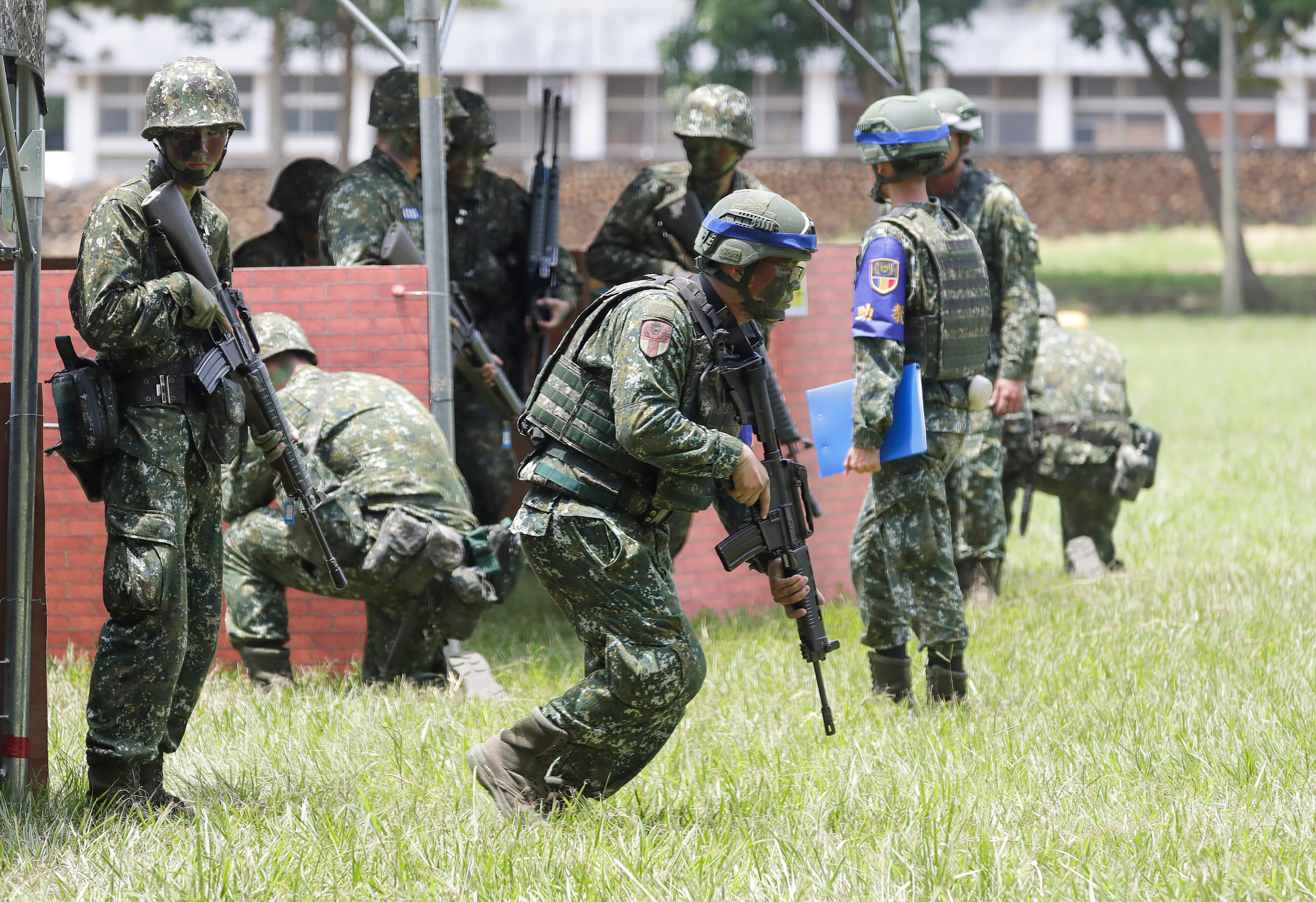 Taiwanese soldiers holding firearms take part in a military training in Taichung