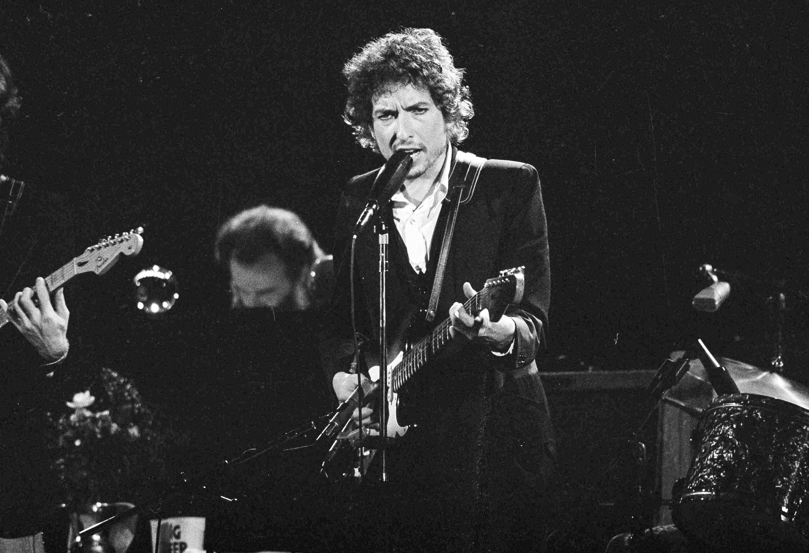 Musician Bob Dylan belts out a tune with members of The Band during a concert at the Forum in Los Angeles, on 15 February 1974