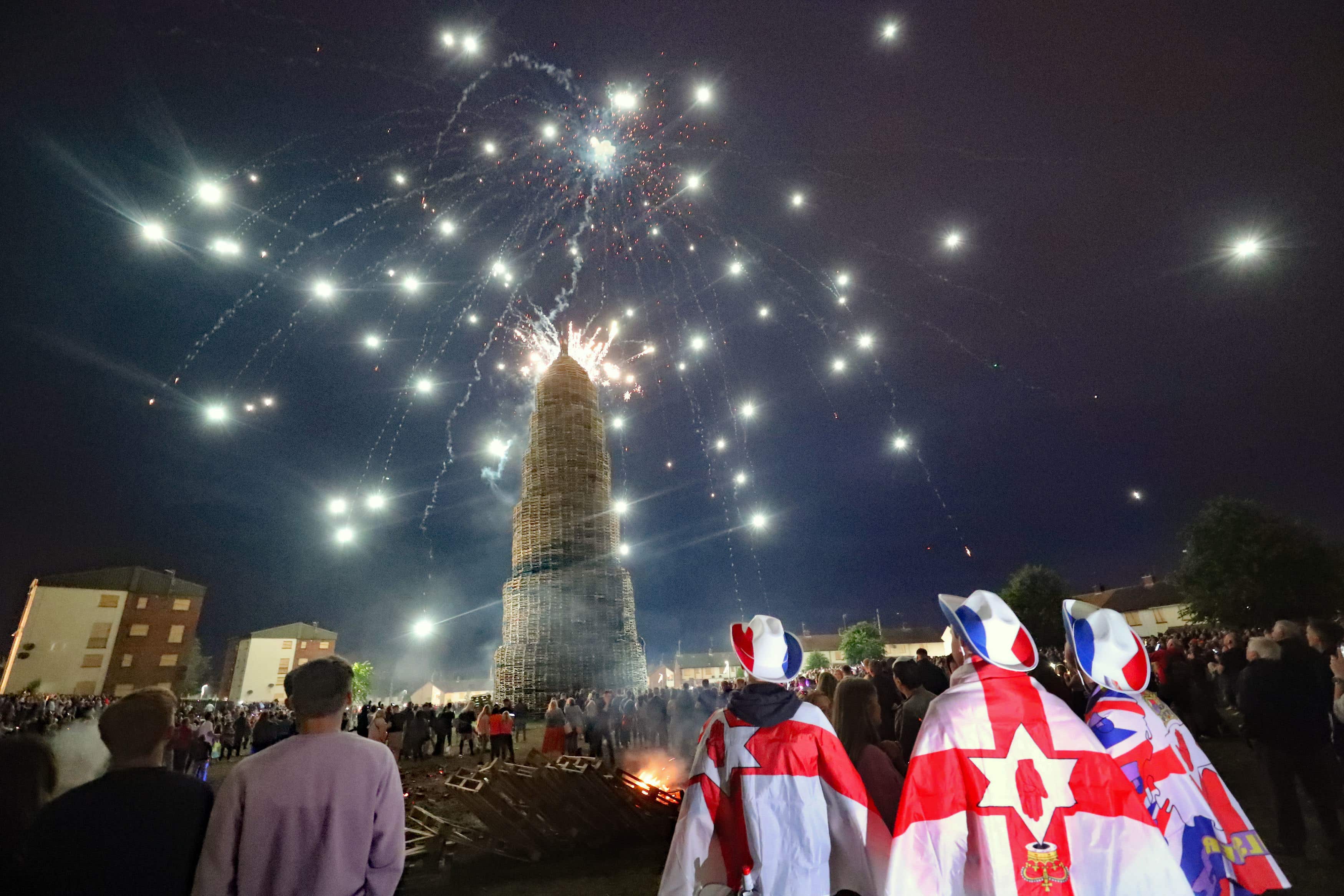 Crowds watch a fireworks display before a huge bonfire in the loyalist Corcrain area of Portadown, Co Armagh, in July 2021 (Niall Carson/PA)